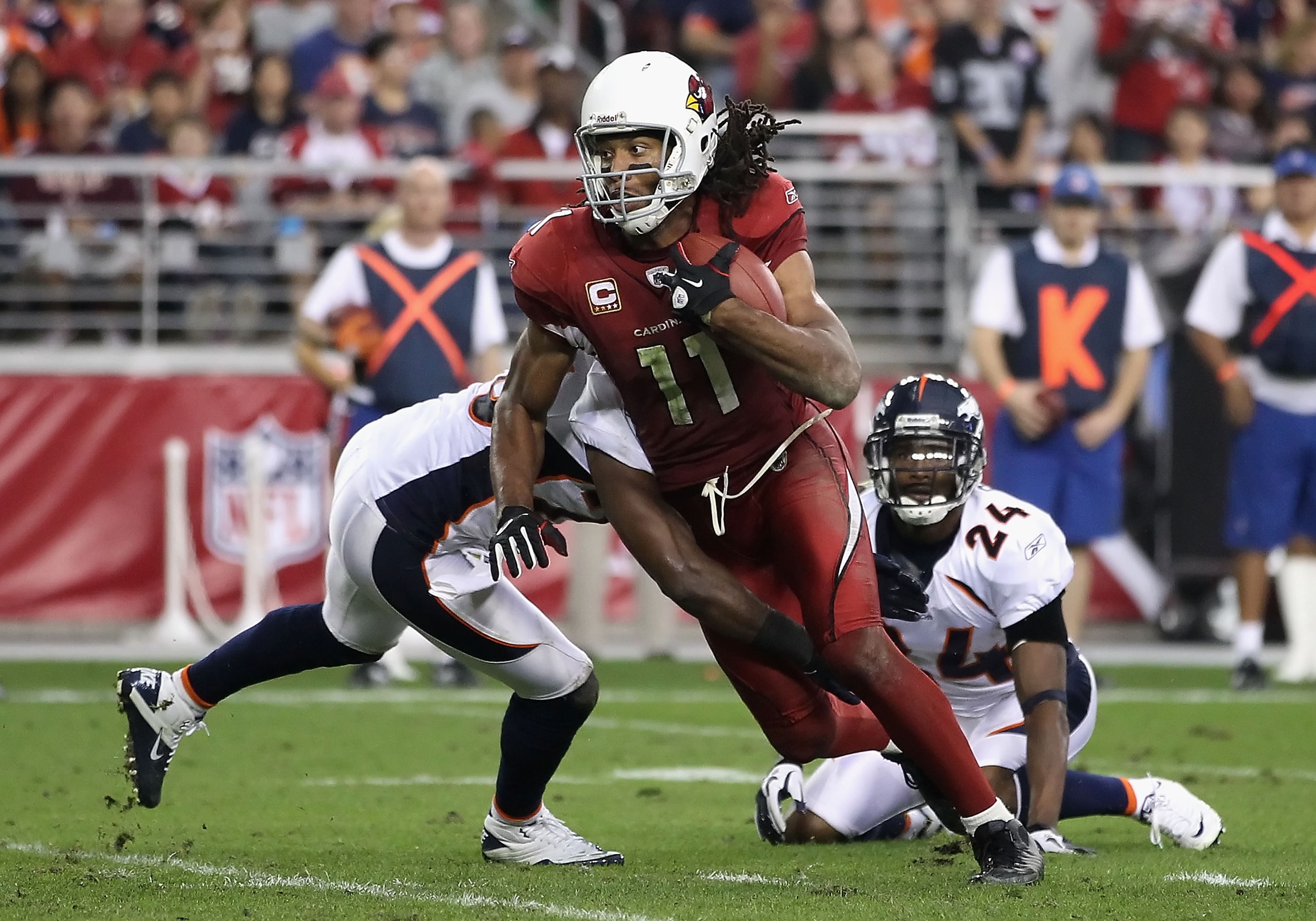 GLENDALE, AZ - DECEMBER 12:  Wide receiver Larry Fitzgerald #11 of the Arizona Cardinals runs with the football after a reception during the NFL game against the Denver Broncos at the University of Phoenix Stadium on December 12, 2010 in Glendale, Arizona