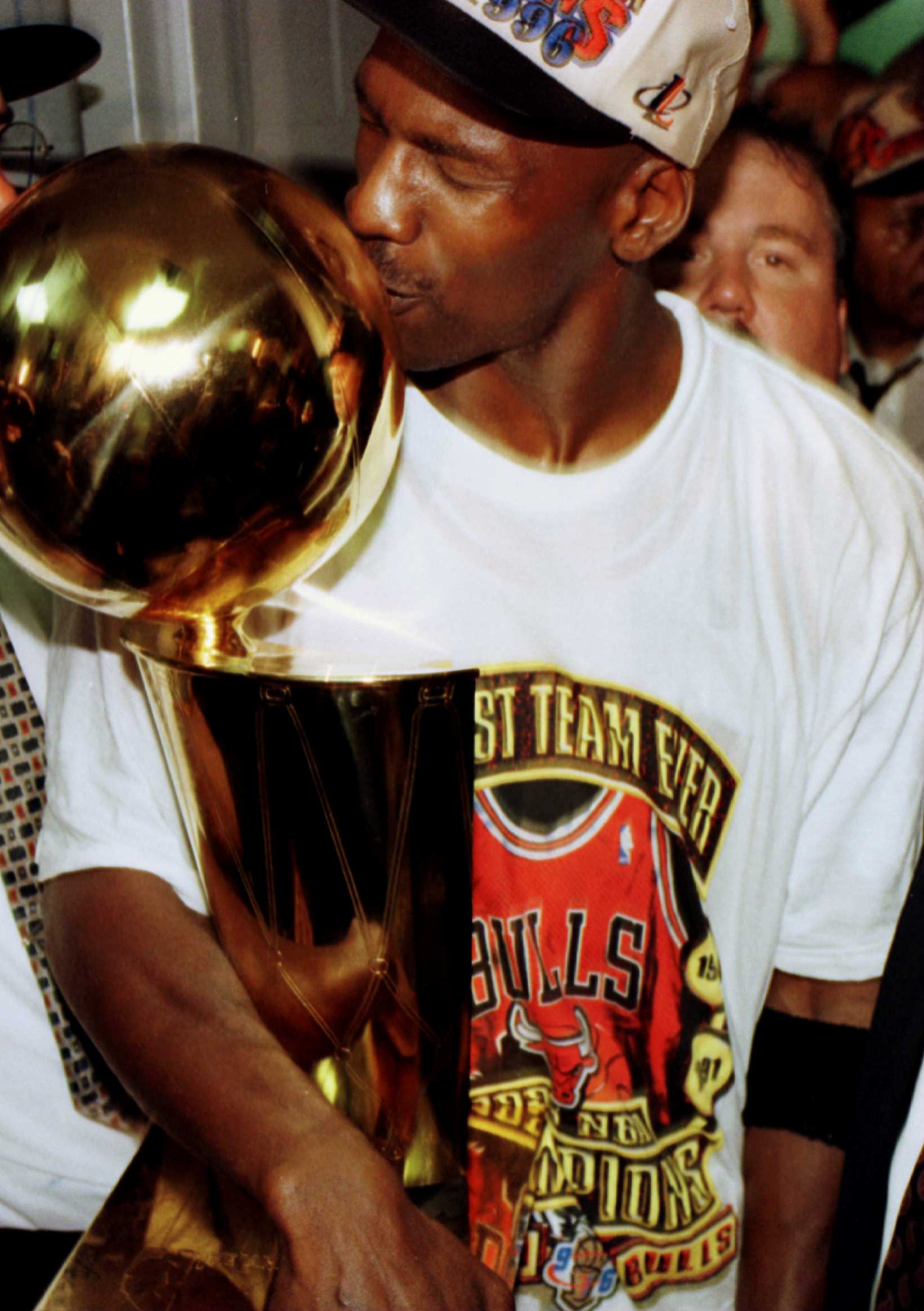 16 Jun 1996: Chicago Bull Michael Jordan kisses the NBA Championship trophy inside the Bulls Locker room at the United Center in Chicago, Illinois. The Bulls went on to defeat the Seattle Supersonics 87-75 to win the 1996 NBA Finals. This is the Bulls'' f