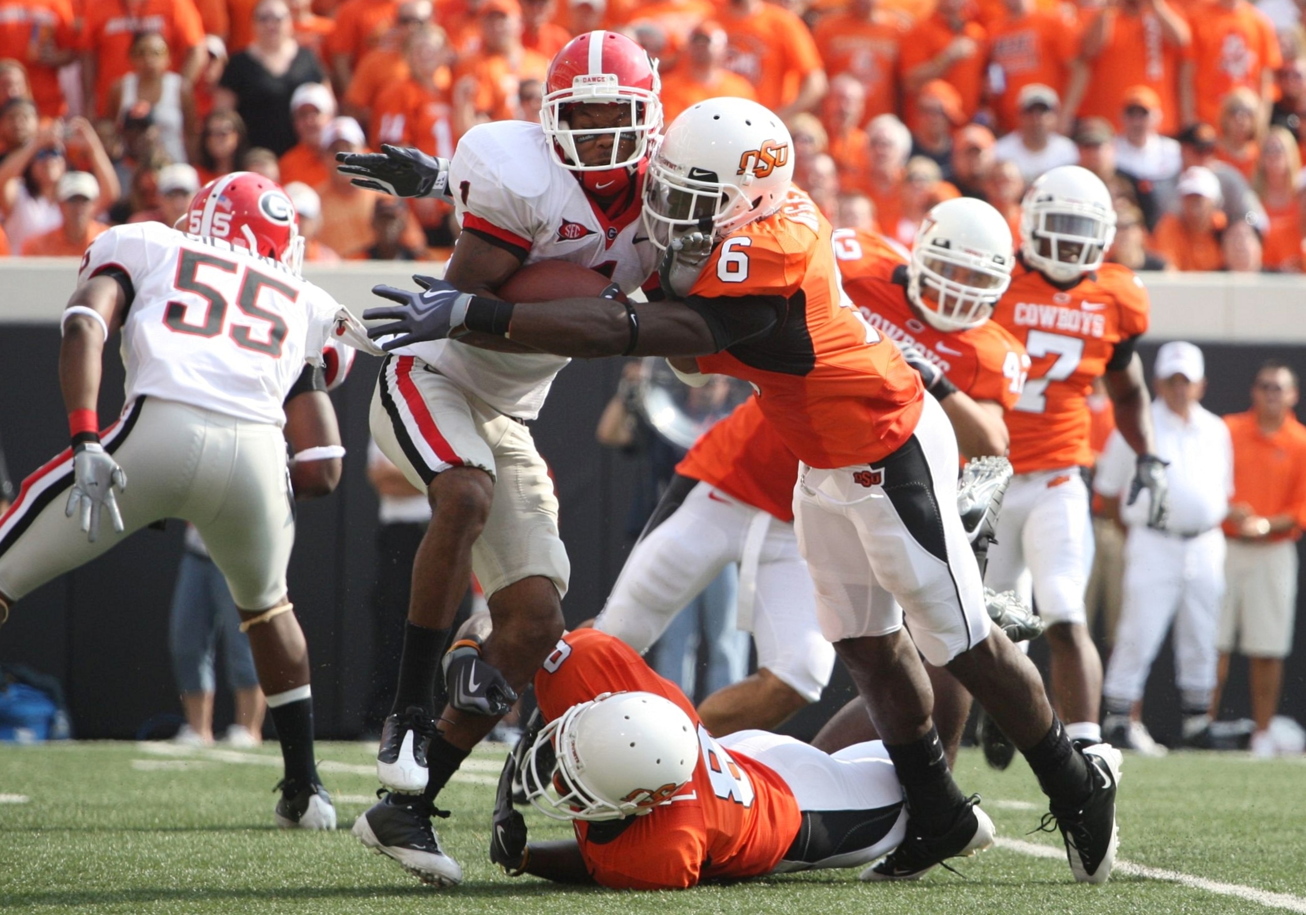 STILLWATER, OK - SEPTEMBER 5: Center back Andrew McGee #6 of the Oklahoma State Cowboys stops wide receiver Branden Smith #1 of the Georgia Bulldogs on a kick off return during the third quarter of the game at Boone Pickens Stadium on September 5, 2009 in