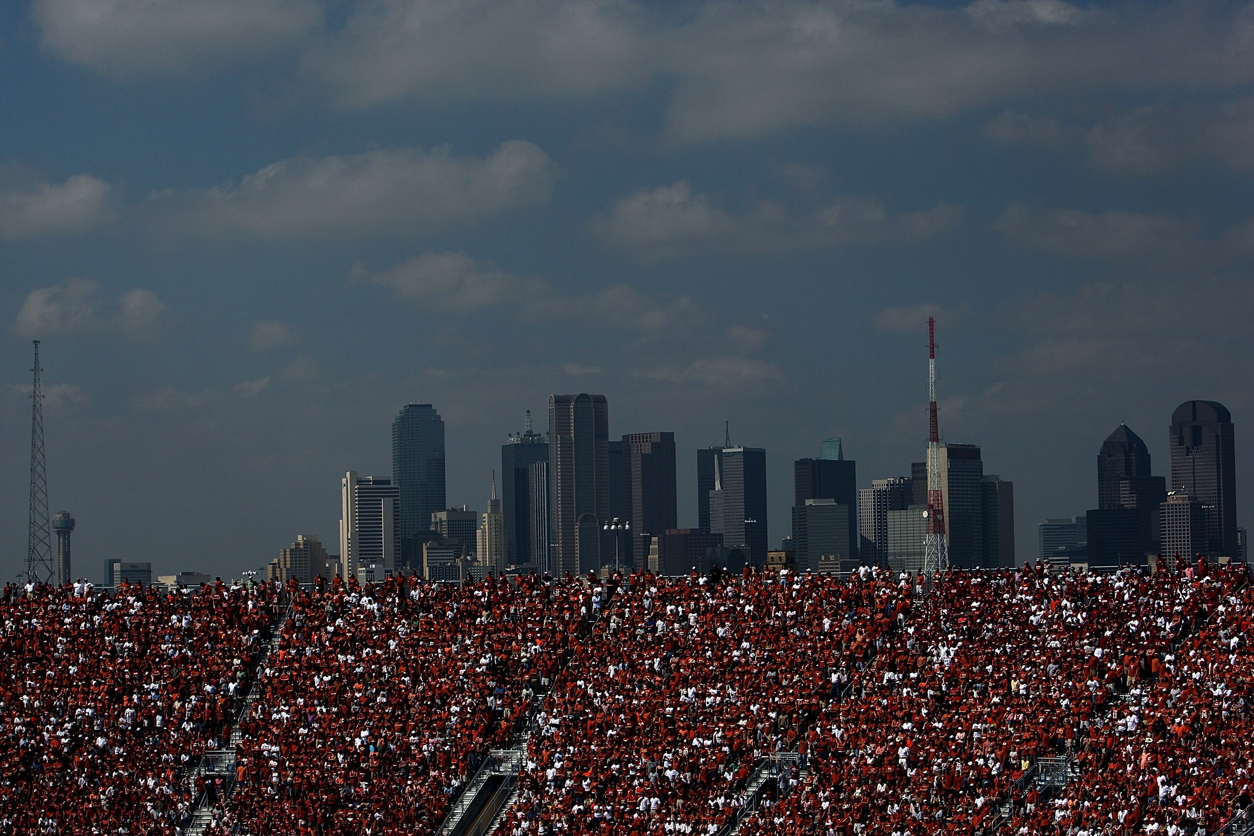 DALLAS - OCTOBER 11:  Texas Longhorns fans fill the stands in front of the Dallas skyline during a game between the Oklahoma Sooners and the Texas Longhorns at the Cotton Bowl on October 11, 2008 in Dallas, Texas.  (Photo by Ronald Martinez/Getty Images)