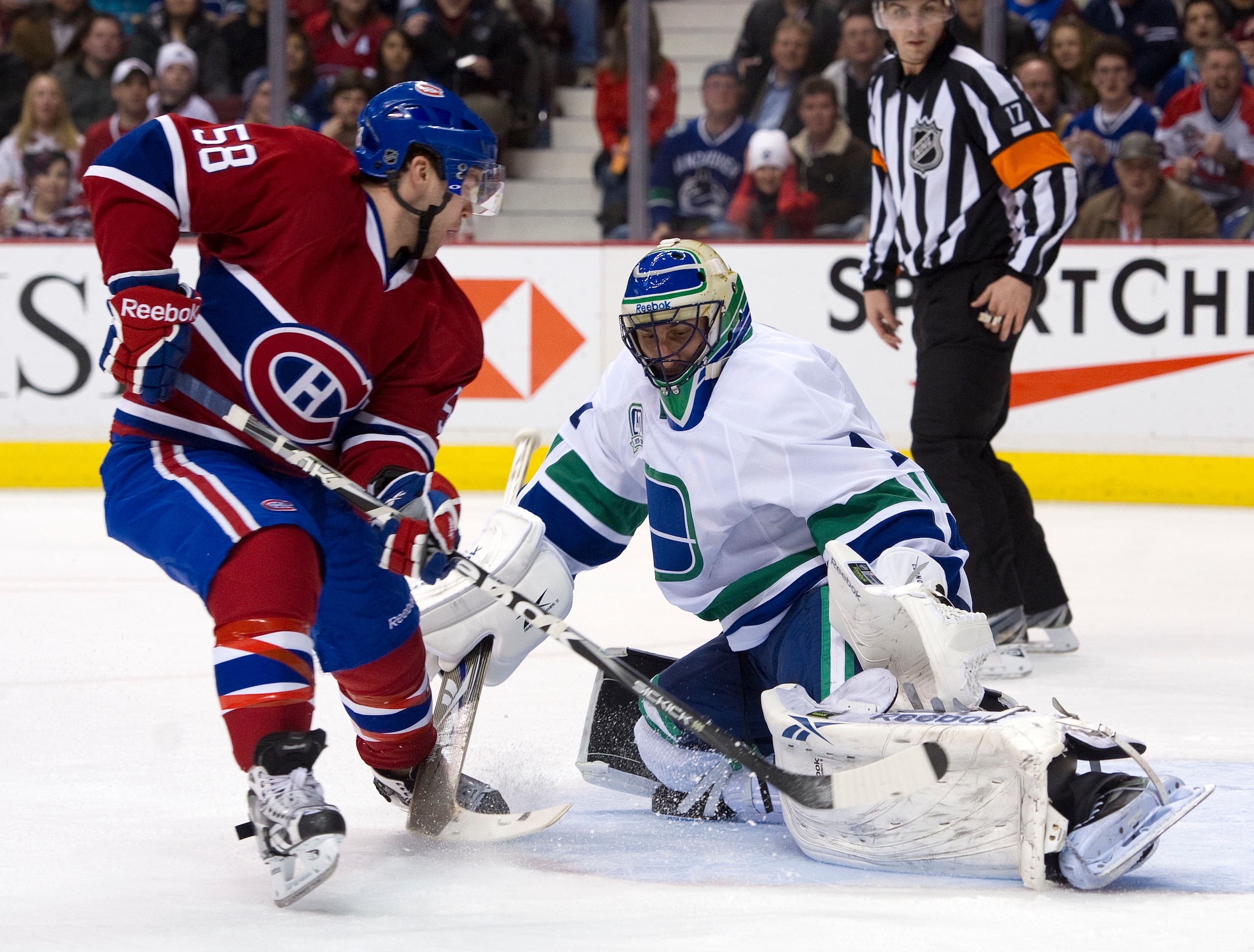 VANCOUVER, CANADA - FEBRUARY 22: David Desharnais #58 of the Montreal Canadiens slides the puck under goalie Roberto Luongo #1 of the Vancouver Canucks for a goal during the first period in NHL action on February 22, 2011 at Rogers Arena in Vancouver, Bri