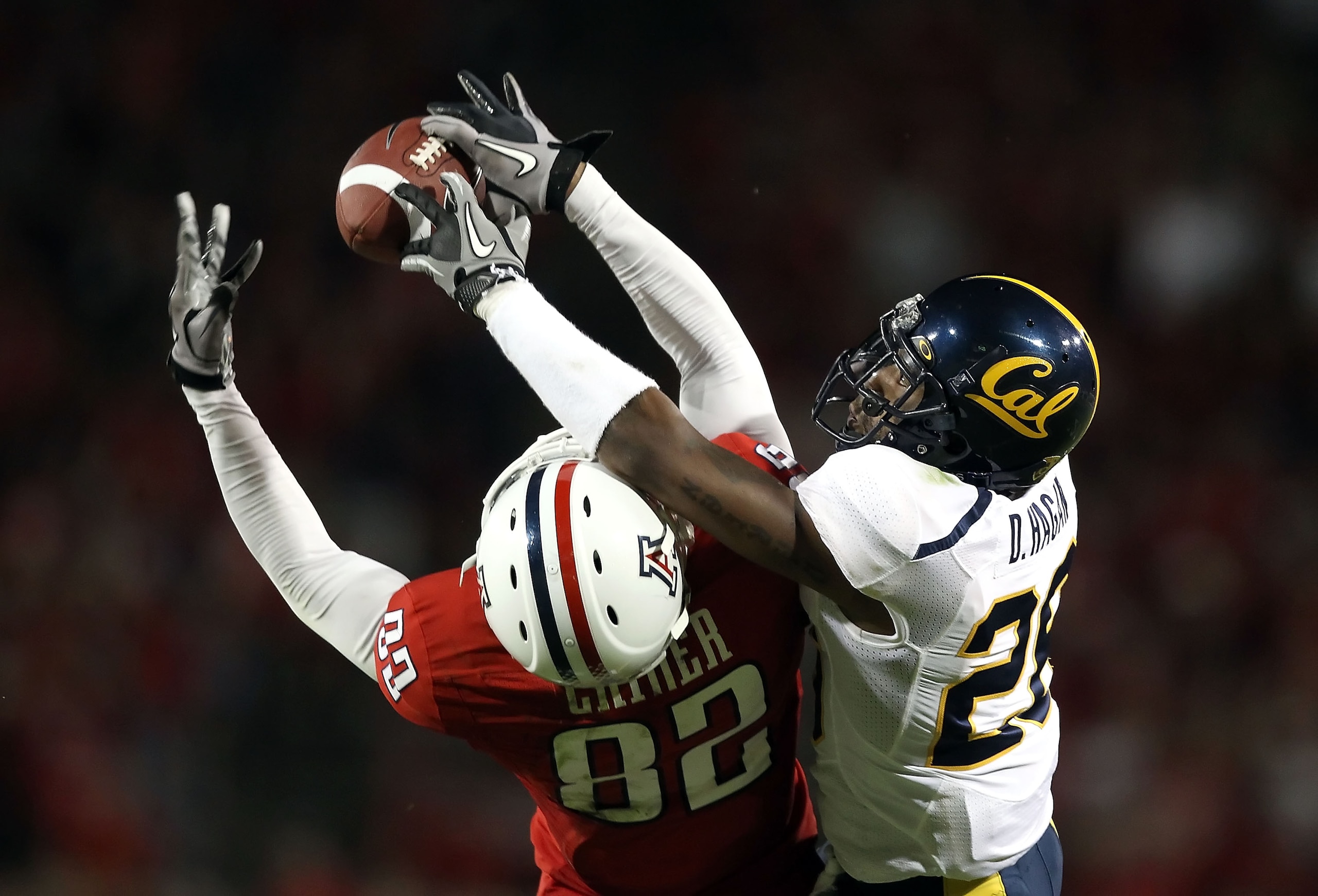 TUCSON, AZ - SEPTEMBER 25:  Wide receiver Juron Criner #82 of the Arizona Wildcats catches a 51 yard reception under pressure from Darian Hagan #26 of the California Golden Bears during the fourth quarter of the college football game at Arizona Stadium on
