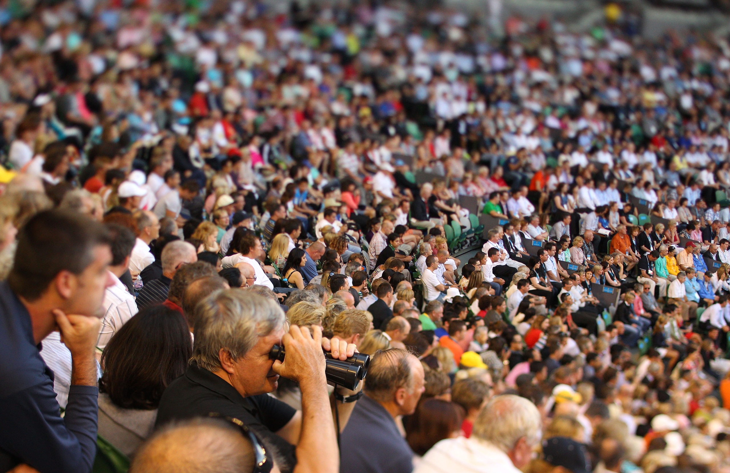 MELBOURNE, AUSTRALIA - JANUARY 27:  (EDITORS NOTE: A TILT AND SHIFT LENS WAS USED IN THE CREATION OF THIS IMAGE.) Fans watch the semi final match between Novak Djokovic of Serbia and Roger Federer of Switzerland during day eleven of the 2011 Australian Op