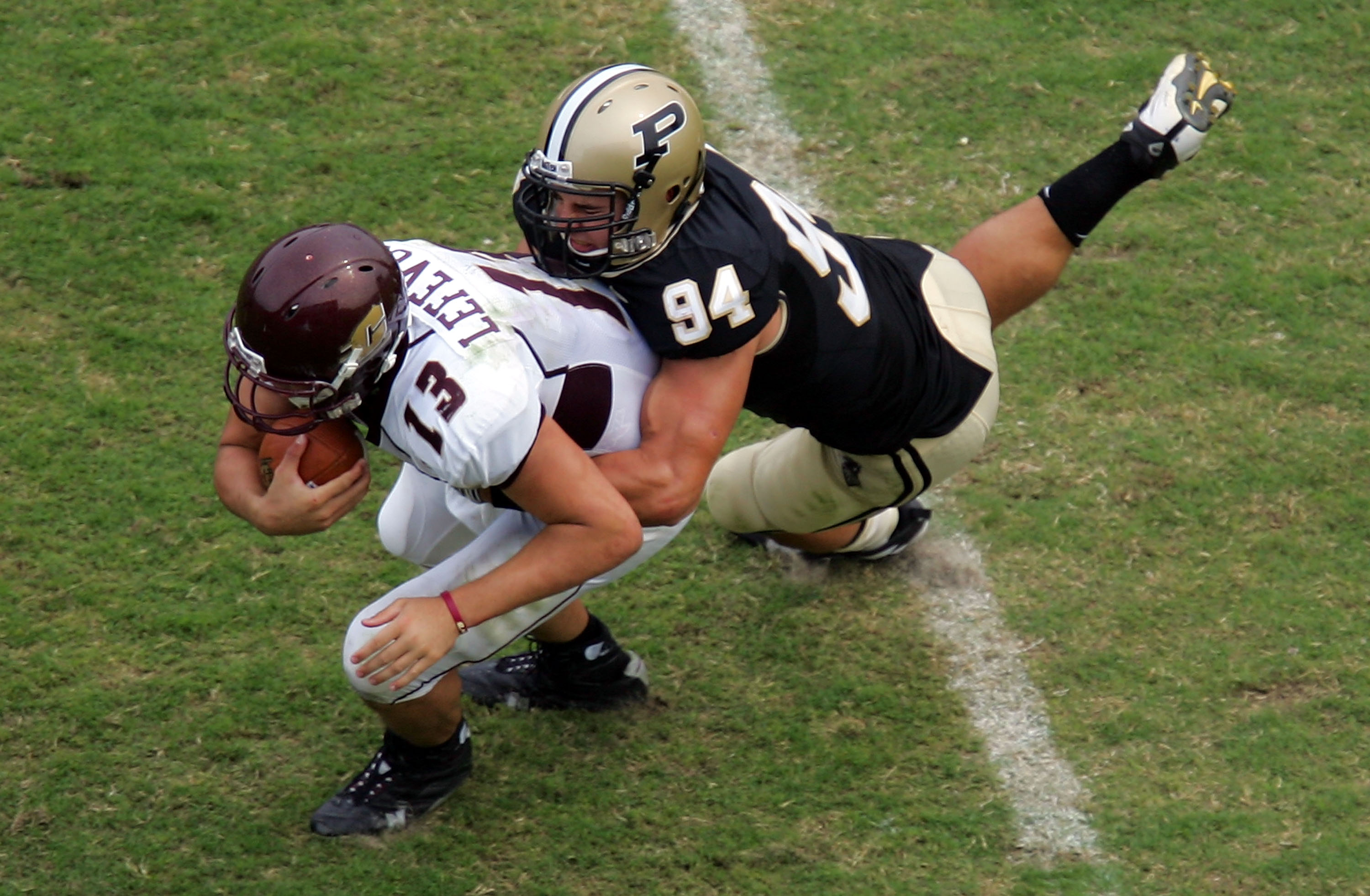 WEST LAFAYETTE, IN - SEPTEMBER 20:  Quarterback Dan LeFevour #13 of the Central Michigan Chippewas is tackled by Ryan Kerrigan #94 of the Purdue Boilermakers at Ross-Ade Stadium on September 20, 2008 in West Lafayette, Indiana.  (Photo by Ronald Martinez/