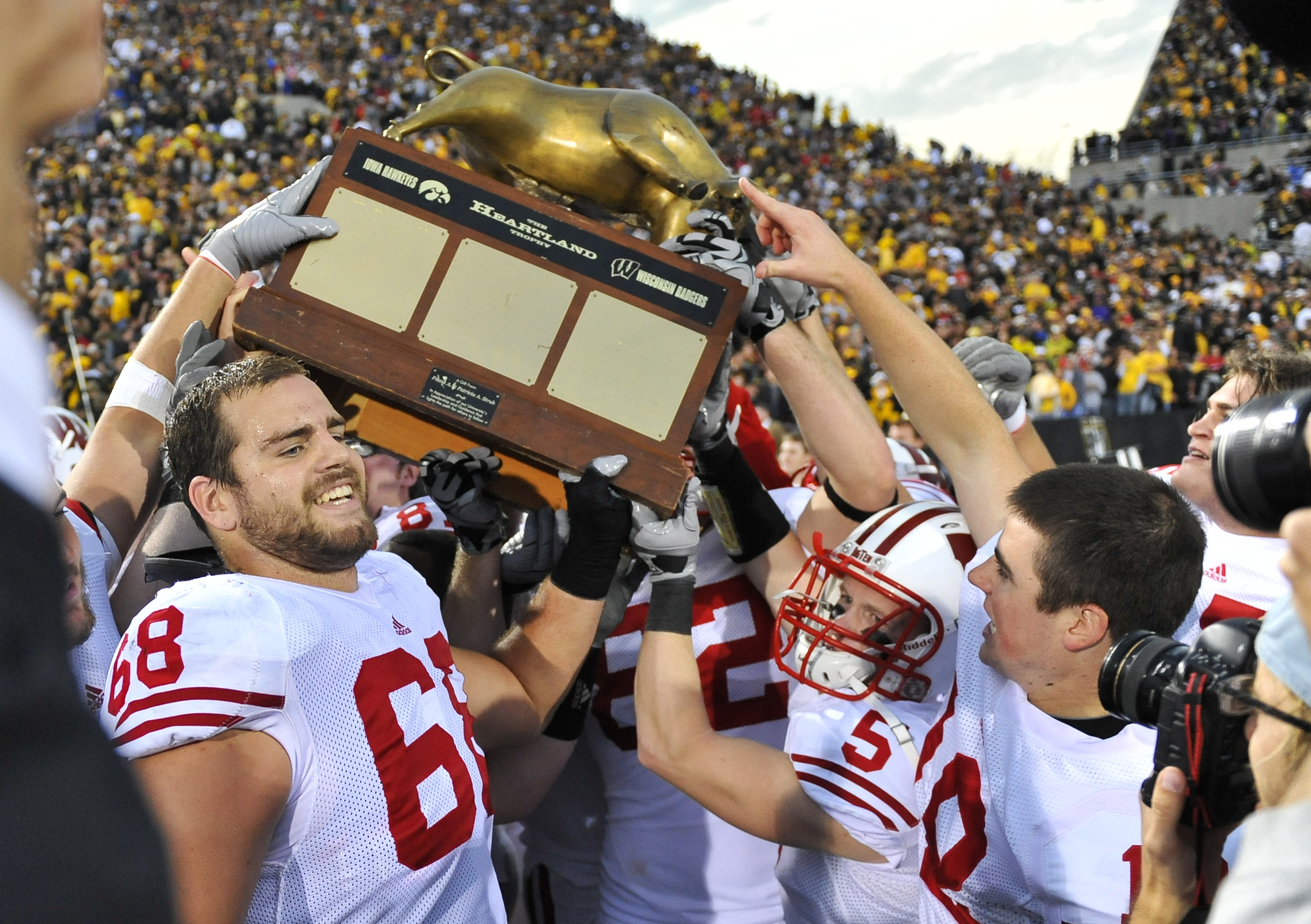 IOWA CITY, IA - OCTOBER 23: Offensive lineman Gabe Carimi #68 of the Wisconsin Badgers holds the Heartland Trophy with his teammates as they celebrate their victory of the University of Iowa Hawkeyes at Kinnick Stadium on October 23, 2010 in Iowa City, Io
