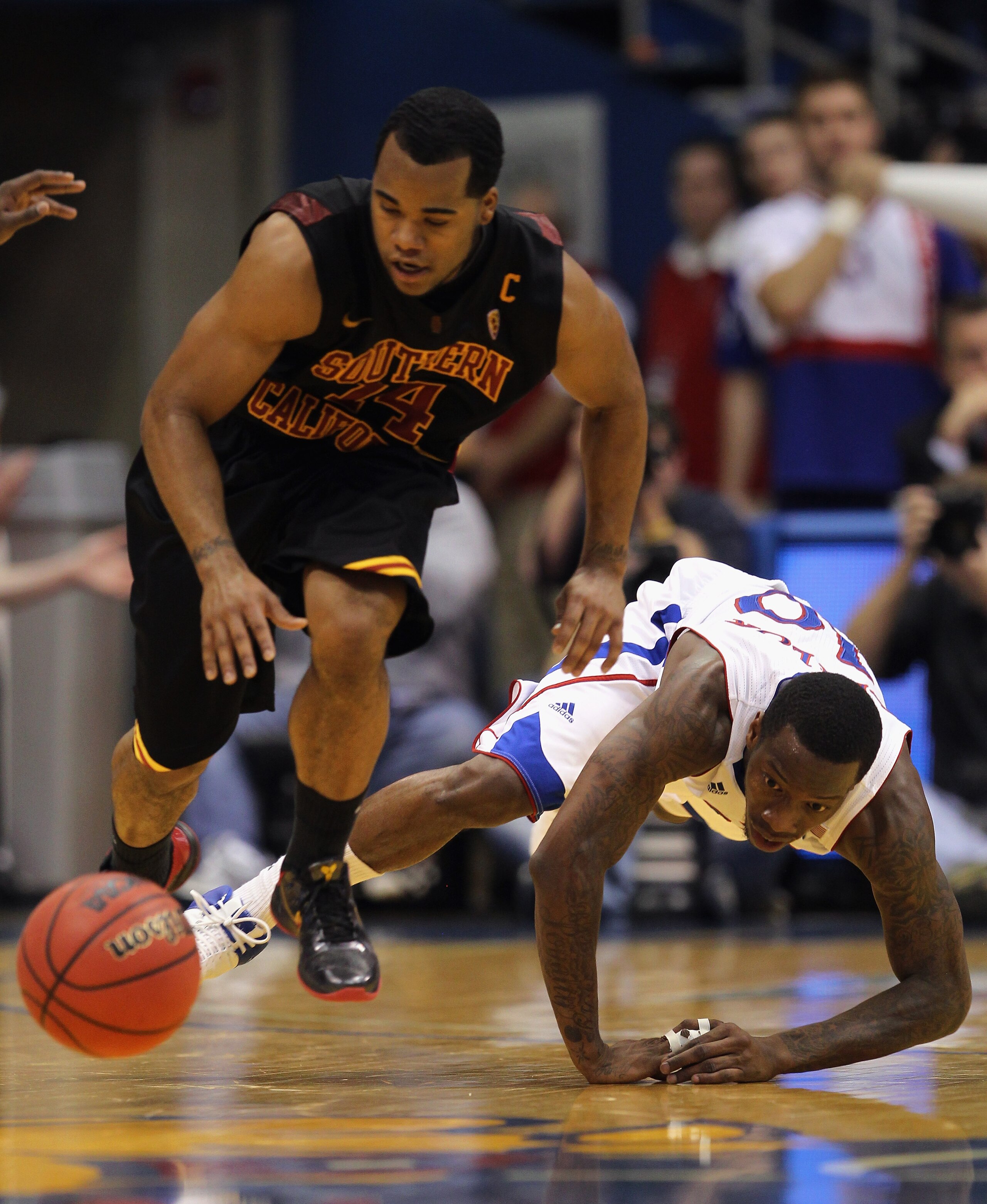 LAWRENCE, KS - DECEMBER 18:  Donte Smith #14 of the USC Trojans and Tyshawn Taylor #10 of the Kansas Jayhawks chase a loose ball during the game on December 18, 2010 at Allen Fieldhouse in Lawrence, Kansas.  (Photo by Jamie Squire/Getty Images)
