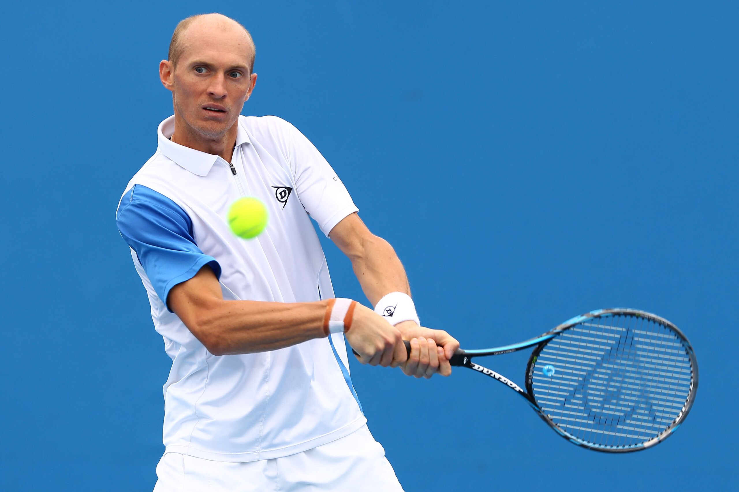 MELBOURNE, AUSTRALIA - JANUARY 17:  Nikolay Davydenko of Russia plays a backhand in his first round match against Florian Mayer of Germany during day one of the 2011 Australian Open at Melbourne Park on January 17, 2011 in Melbourne, Australia.  (Photo by