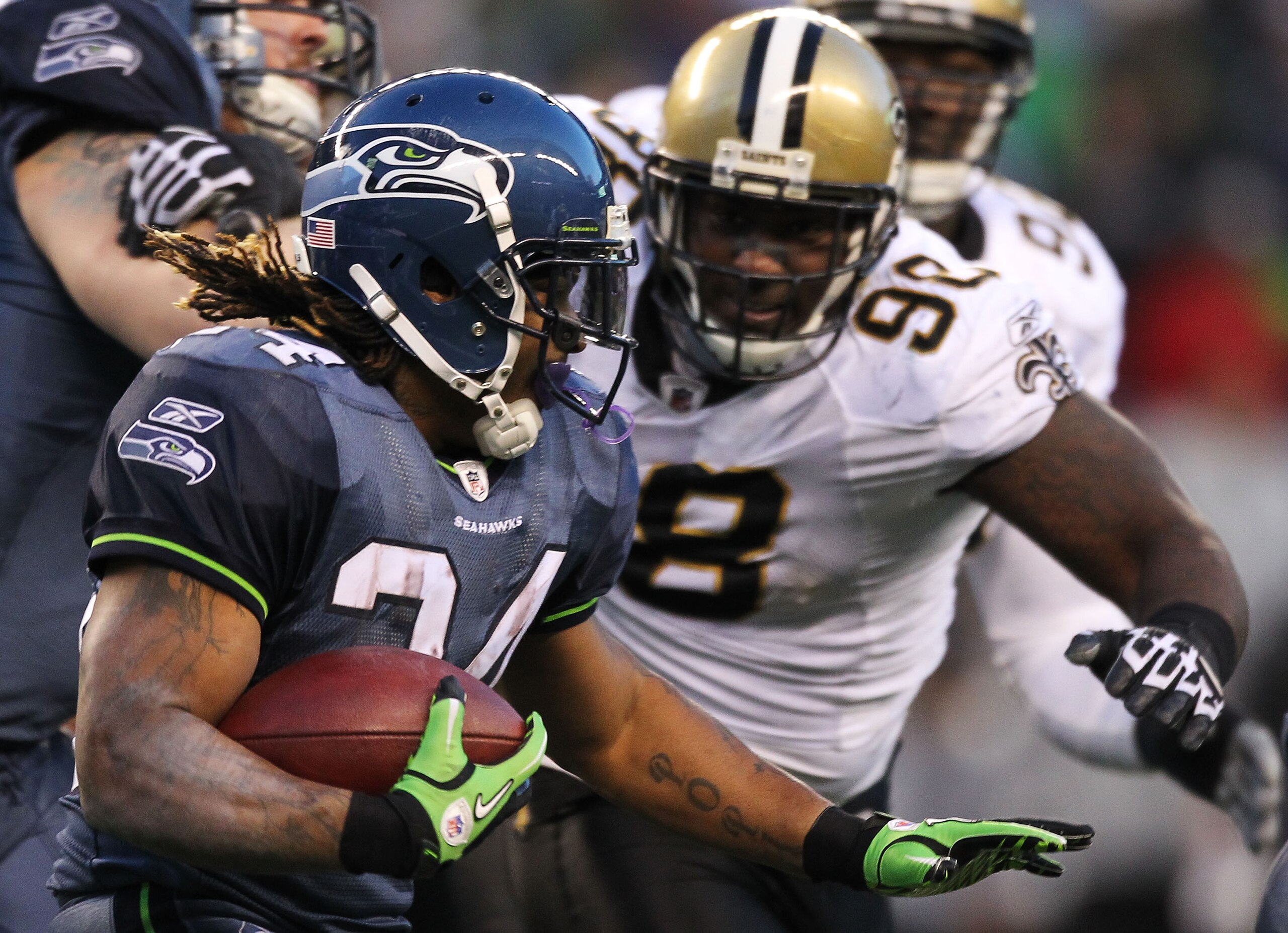 SEATTLE, WA - JANUARY 08:  Marshawn Lynch #24 of the Seattle Seahawks runs down field against Sedrick Ellis #98 of the New Orleans Saints during the 2011 NFC wild-card playoff game at Qwest Field on January 8, 2011 in Seattle, Washington.  (Photo by Otto