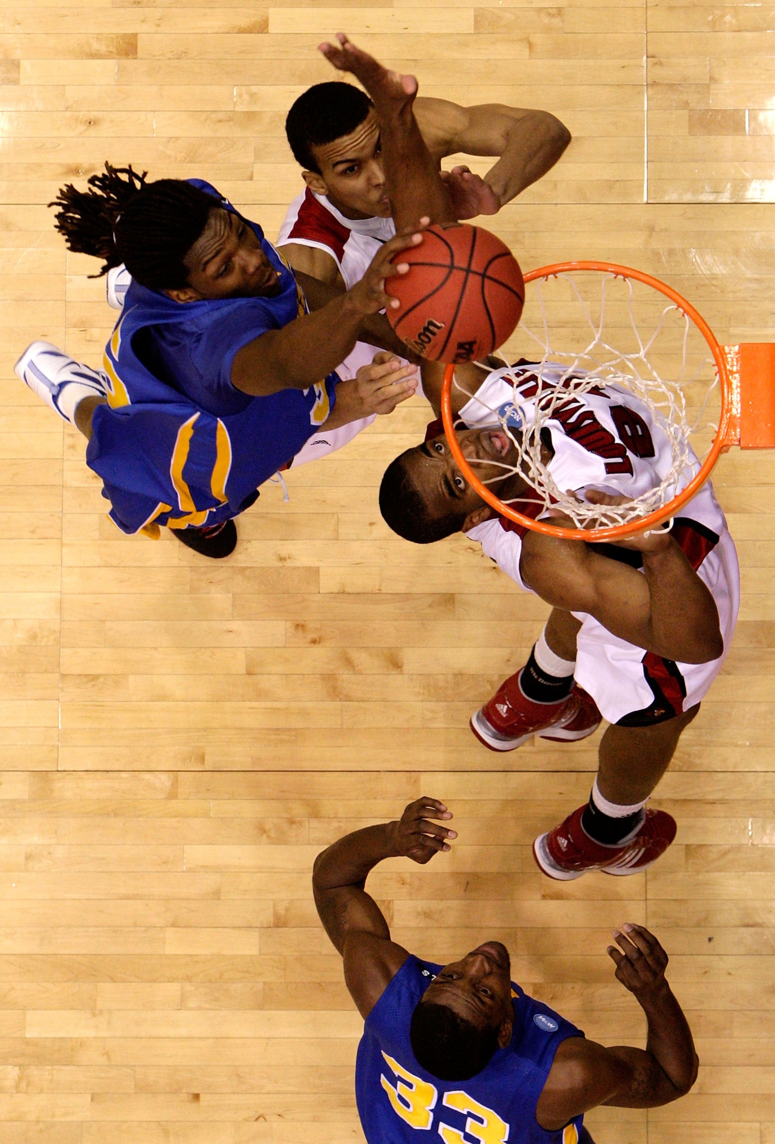 DAYTON, OH - MARCH 20: Kenneth Faried #35 of the Morehead State Eagles drives to the hoop against Jared Swopshire #21 and Samardo Samuels #24 of the Louisville Cardinals during the first round of the NCAA Division I Men's Basketball Tournament at the Univ