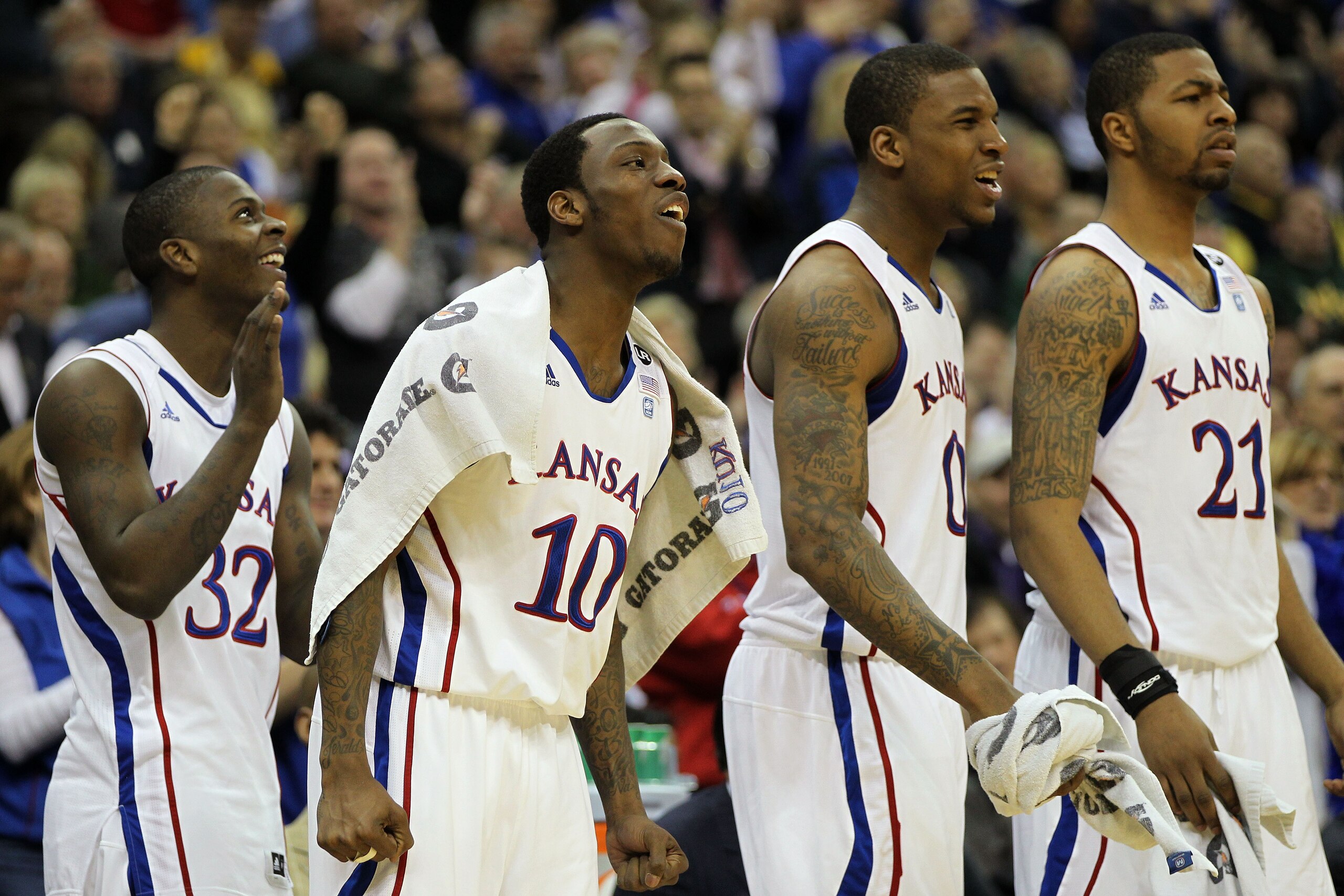 KANSAS CITY, MO - MARCH 10:  Josh Selby #32, Tyshawn Taylor #10, Thomas Robinson #0, and Markieff Morris #21 of the Kansas Jayhawks cheer from the bench during their quarterfinal game against the Oklahoma State Cowboys in the 2011 Phillips 66 Big 12 Men's