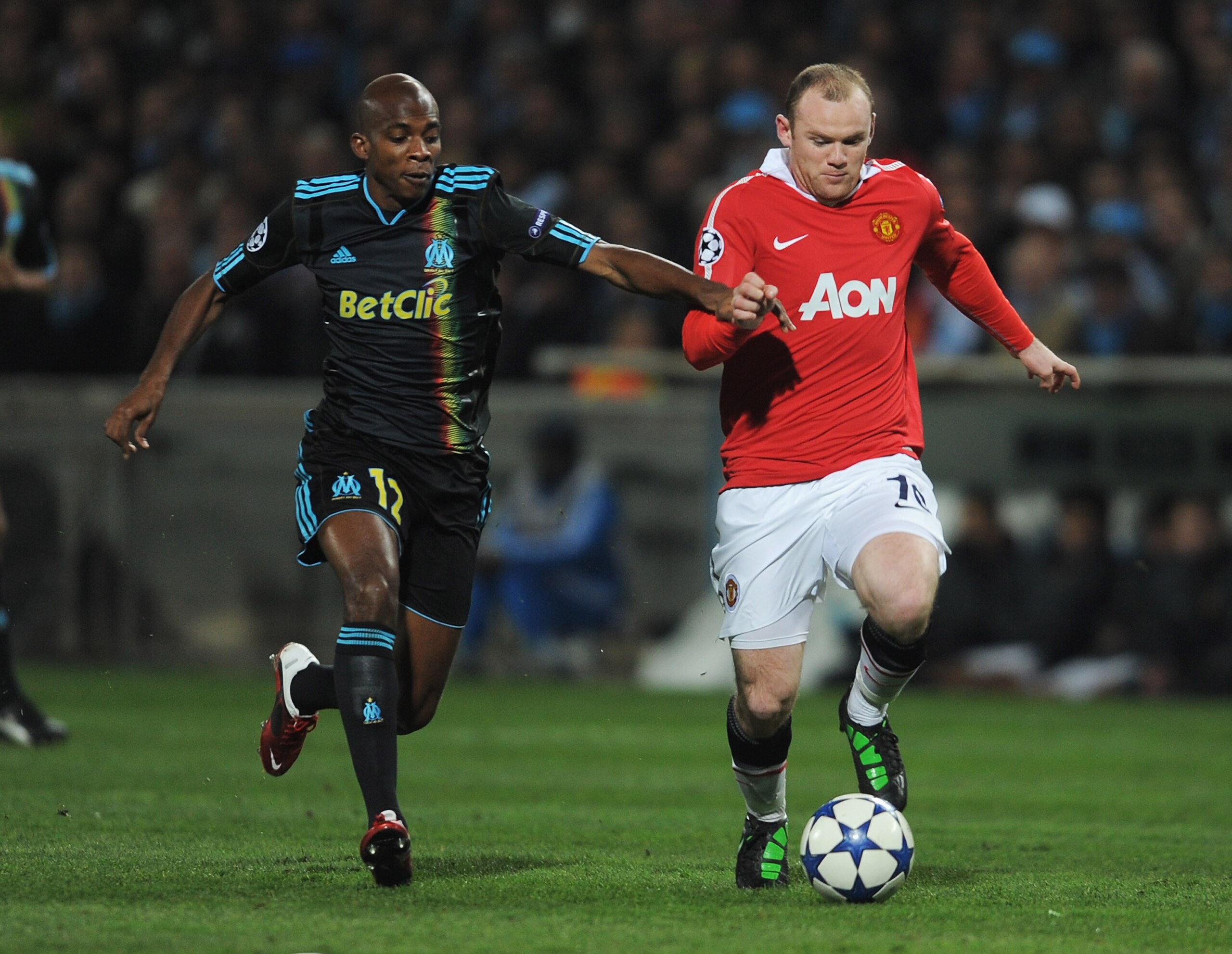 MARSEILLE, FRANCE - FEBRUARY 23: Wayne Rooney of Manchester United is closed down by  Charles Kabore of Marseille during the UEFA Champions League round of 16 first leg match between Marseille and Manchester United at the Stade Velodrome on February 23, 2