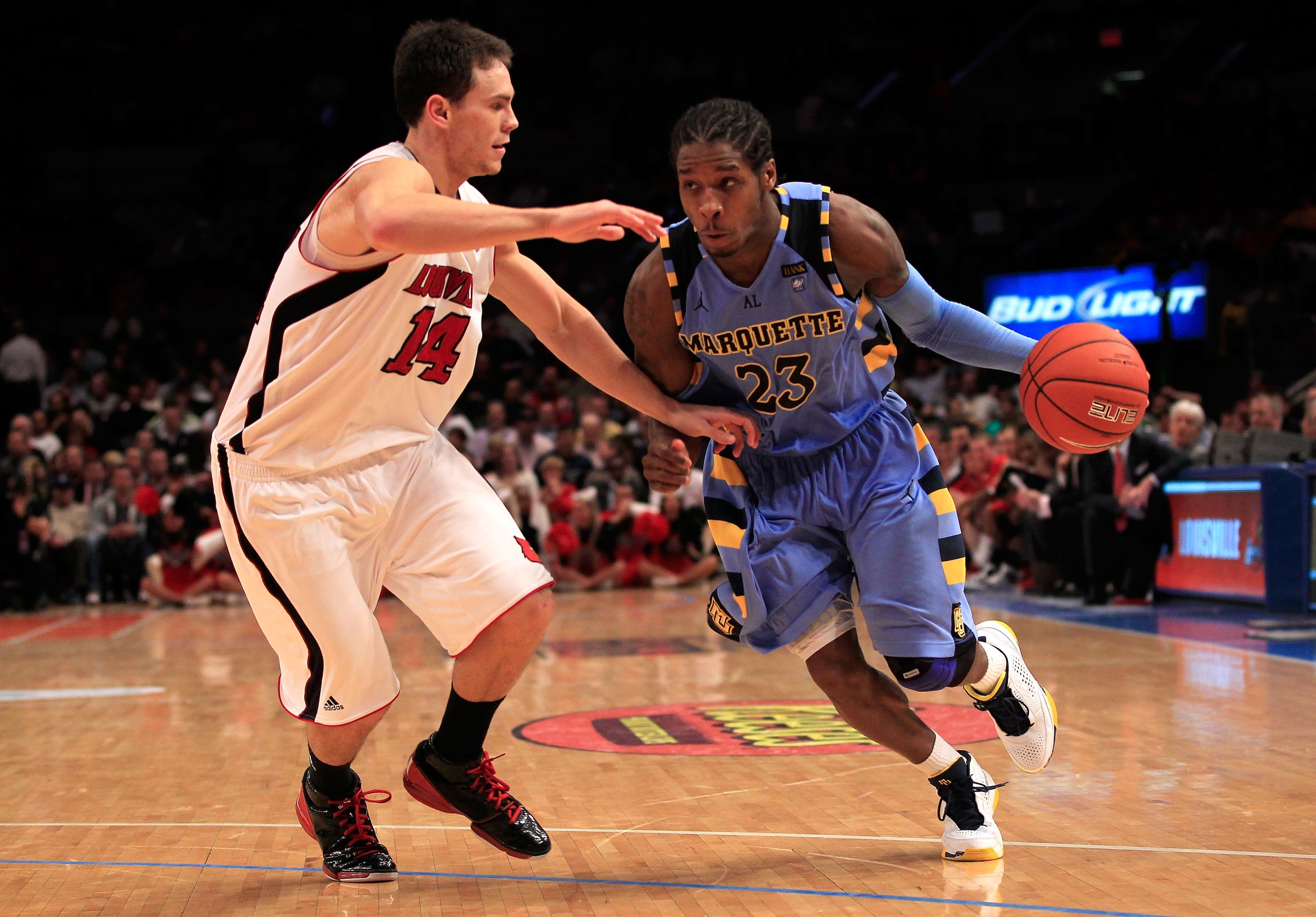 NEW YORK, NY - MARCH 10: Dwight Buycks #23 of the Marquette Golden Eagles drives with the ball against Kyle Kuric #14 of the Louisville Cardinals during the quarterfinals of the 2011 Big East Men's Basketball Tournament presented by American Eagle Outfitt