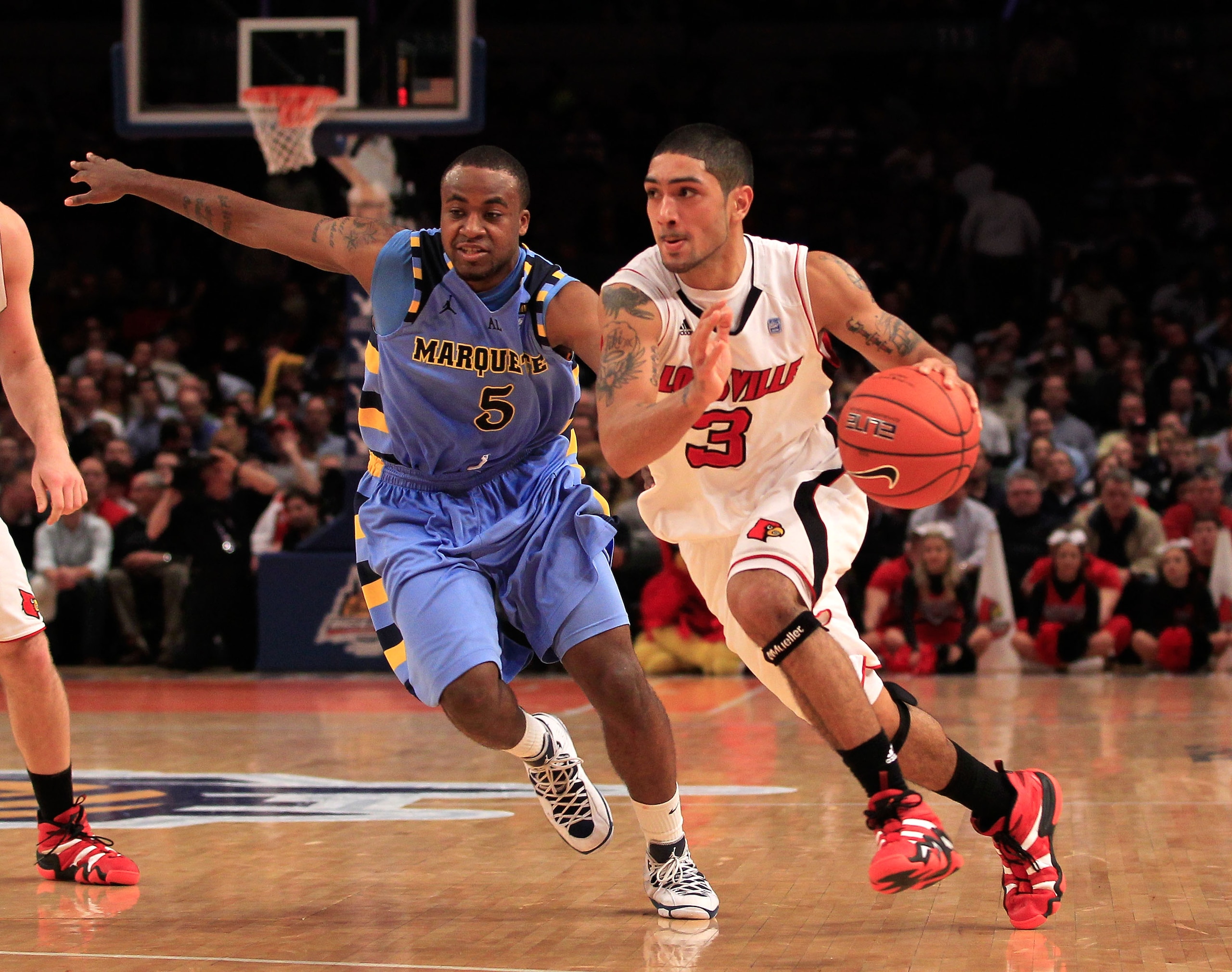 NEW YORK, NY - MARCH 10:  Peyton Siva #3 of the Louisville Cardinals brings the ball up court against Junior Cadougan #5 of the Marquette Golden Eagles during the quarterfinals of the 2011 Big East Men's Basketball Tournament presented by American Eagle O