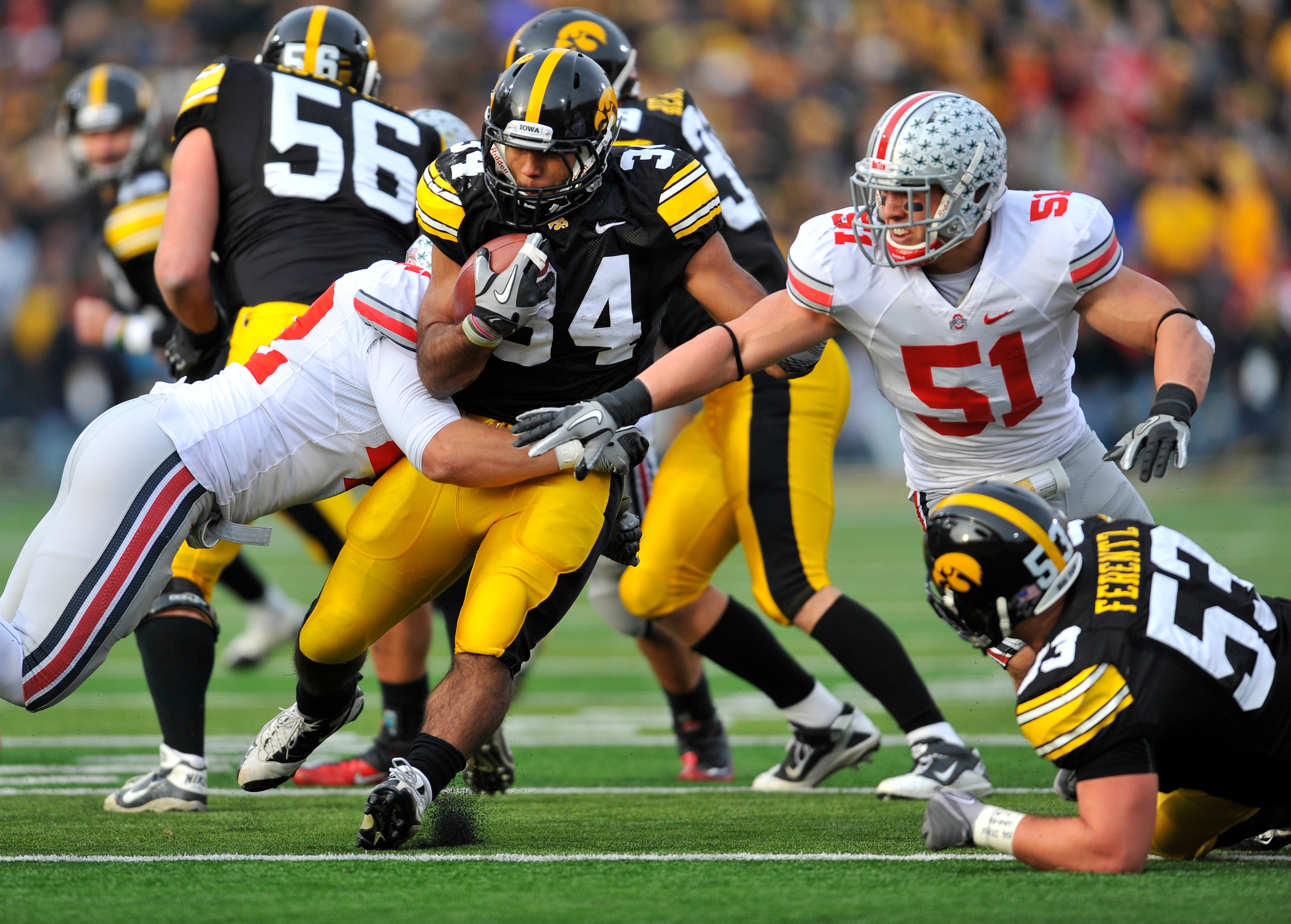 IOWA CITY, IA - NOVEMBER 20:  Running back Marcus Coker #34 of the University of Iowa Hawkeyes is tackled by line backer Andrew Sweat #42 of the Ohio State Buckeyes during the second half of play at Kinnick Stadium on November 20, 2010 in Iowa City, Iowa.