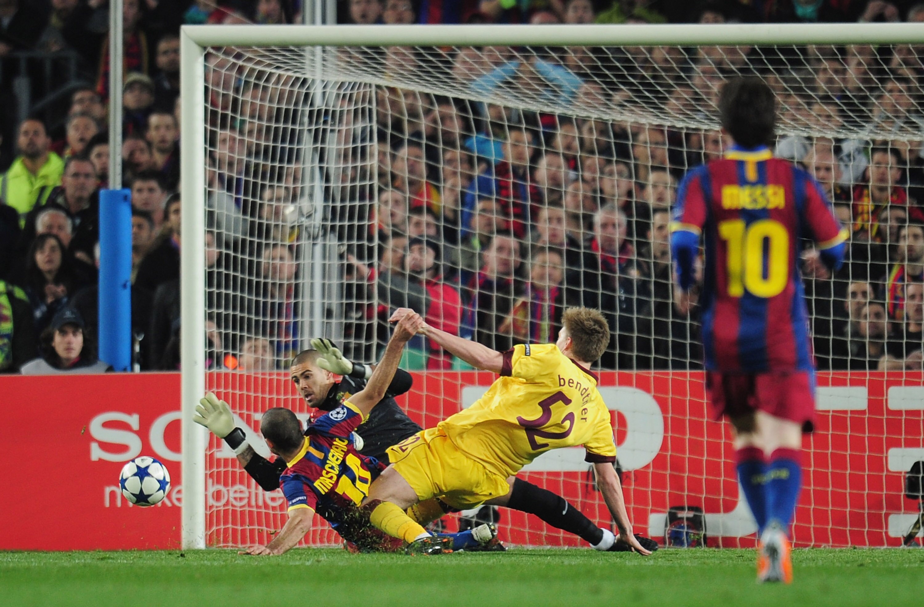 BARCELONA, SPAIN - MARCH 08:  Nicklas Bendtner of Arsenal is challenged by Javier Mascherano and goalkeeper Victor Valdes of Barcelona during the UEFA Champions League round of 16 second leg match between Barcelona and Arsenal at the Nou Camp Stadium on M