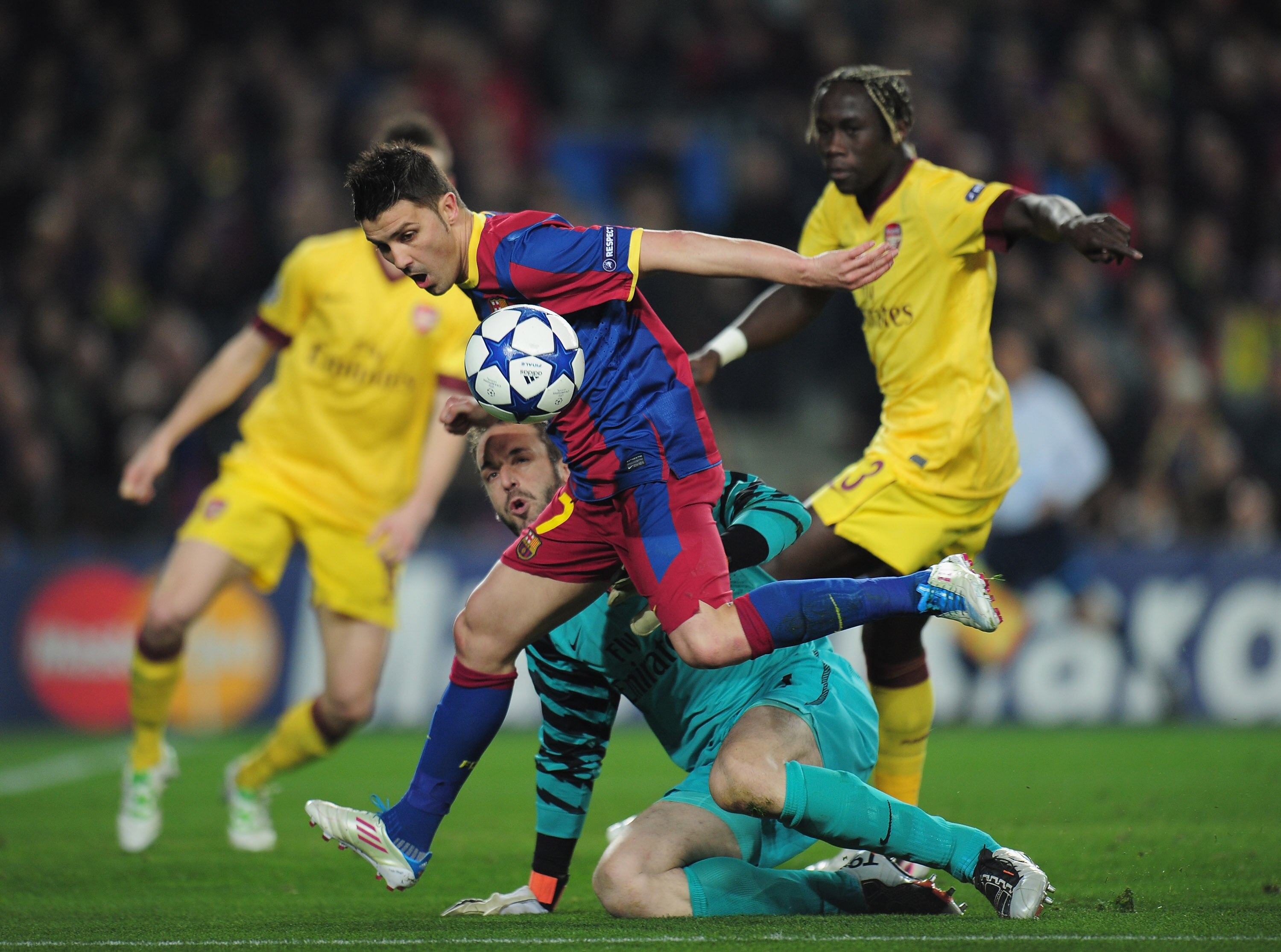 BARCELONA, SPAIN - MARCH 08:  David Villa of Barcelona is tackled by Manuel Almunia and Bacary Sagna of Arsenal during the UEFA Champions League round of 16 second leg match between Barcelona and Arsenal at the Nou Camp Stadium on March 8, 2011 in Barcelo