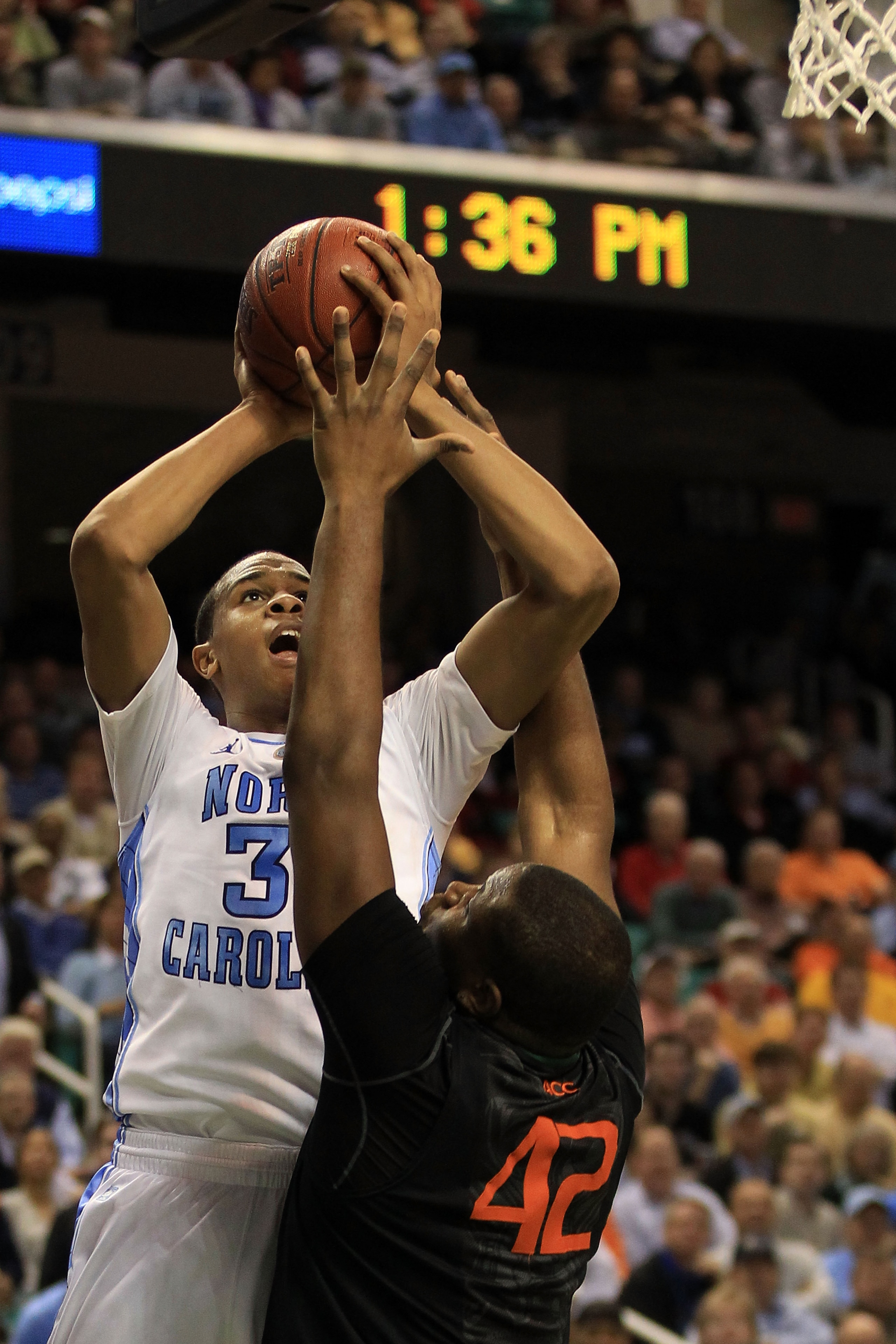 GREENSBORO, NC - MARCH 11:  John Henson #31 of the North Carolina Tar Heels shoots against Reggie Johnson #42 of the Miami Hurricanes during the second half in the quarterfinals of the 2011 ACC men's basketball tournament at the Greensboro Coliseum on Mar