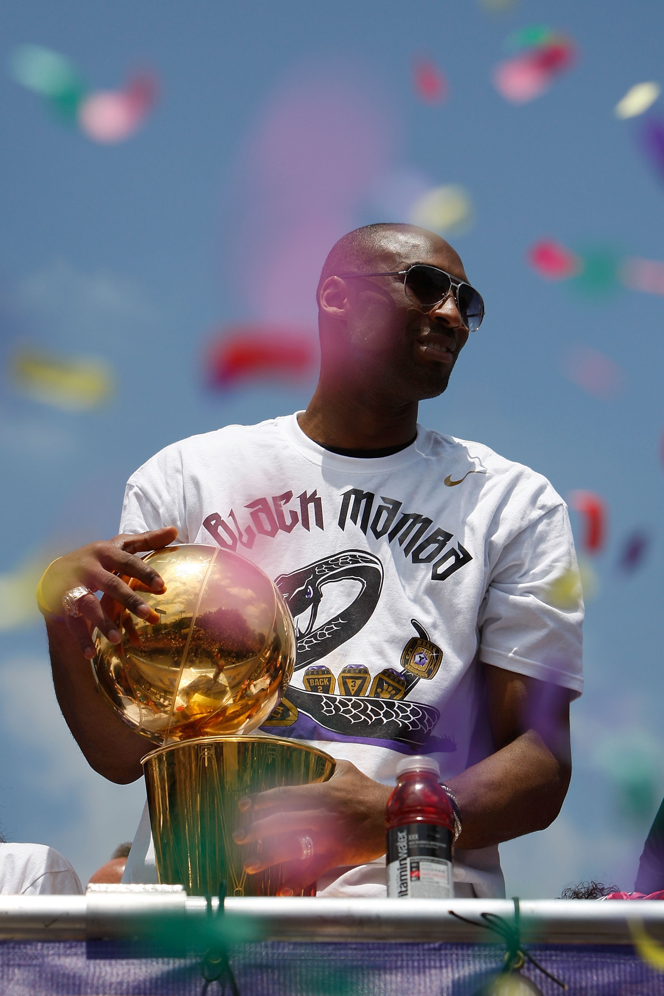 LOS ANGELES, CA - JUNE 21:  Confetti thrown from the crowd falls around Los Angeles Lakers guard Kobe Bryant as he holds the championship trophy while riding in the victory parade for the NBA basketball champion team on June 21, 2010 in Los Angeles, Calif