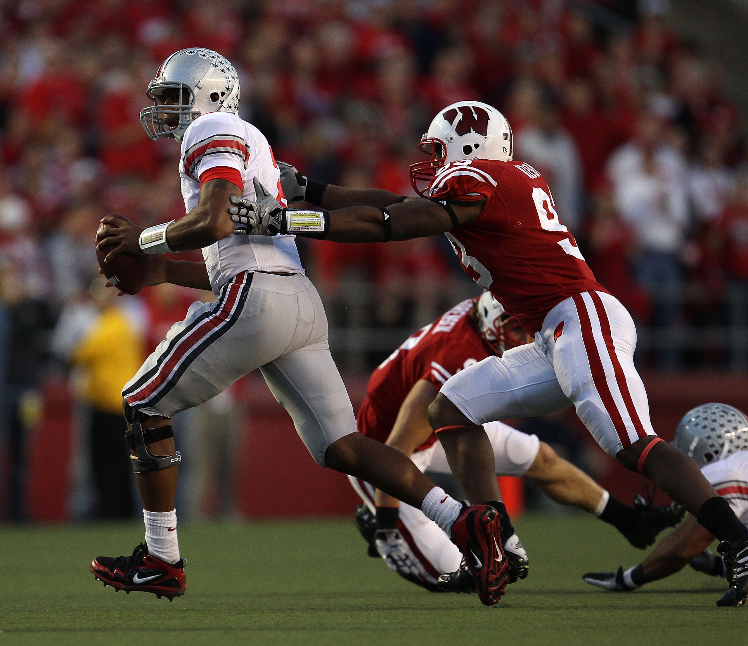 MADISON, WI - OCTOBER 16: Terrelle Pryor #2 of the Ohio State Buckeyes is chased by Louis Nzegwu #93 of the Wisconsin Badgers at Camp Randall Stadium on October 16, 2010 in Madison, Wisconsin. Wisconsin defeated Ohio State 31-18. (Photo by Jonathan Daniel