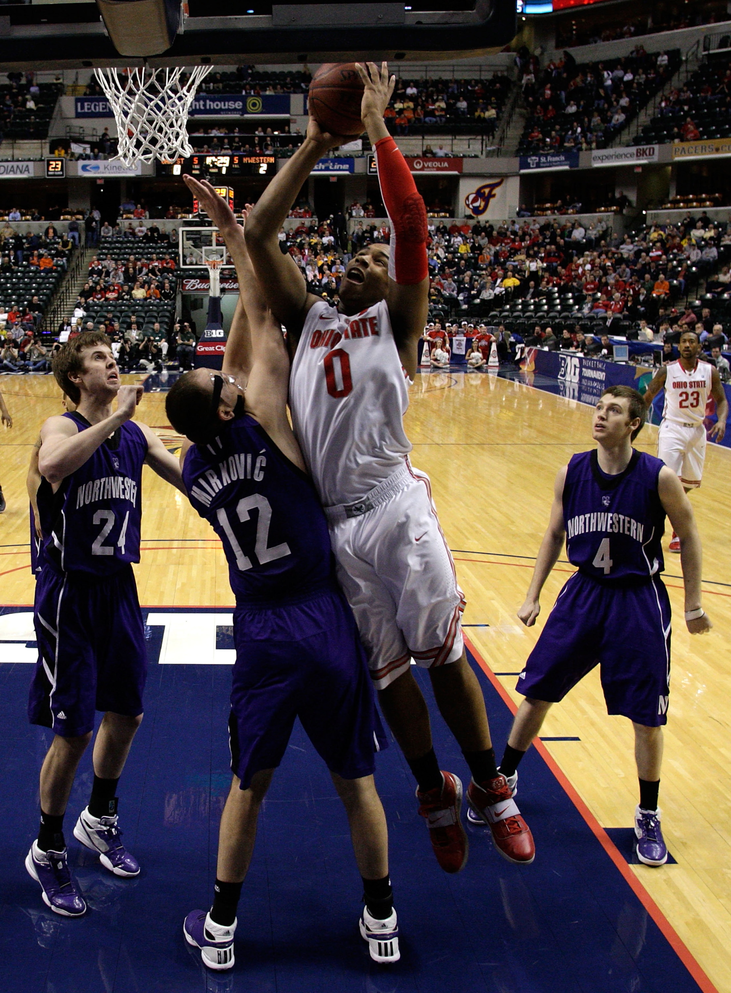 INDIANAPOLIS, IN - MARCH 11:  Jared Sullinger #0 of the Ohio State Buckeyes attempts a shot against Luka Mirkovic #12 of the Northwestern Wildcats during the quarterfinals of the 2011 Big Ten Men's Basketball Tournament at Conseco Fieldhouse on March 11,