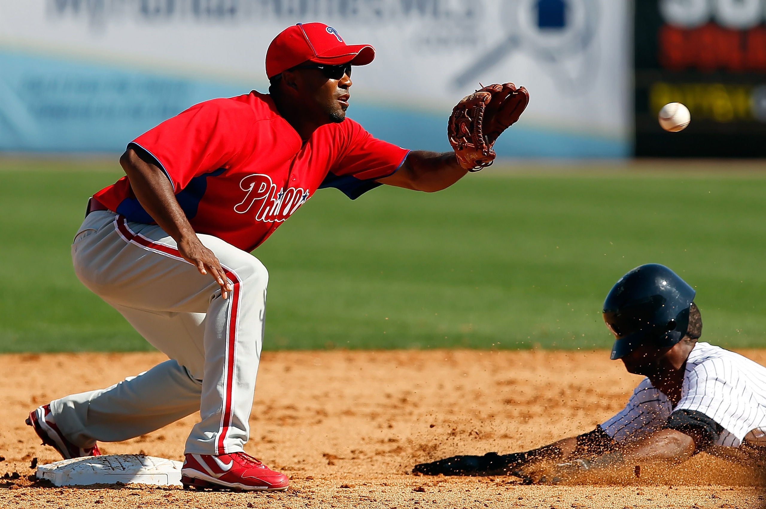 TAMPA, FL - FEBRUARY 26:  Shortstop Josh Barfield #61 of the Philadelphia Phillies takes the throw at second as infielder Eduardo Nunez #67 of the New York Yankees steals second during a Grapefruit League Spring Training Game at George M. Steinbrenner Fie