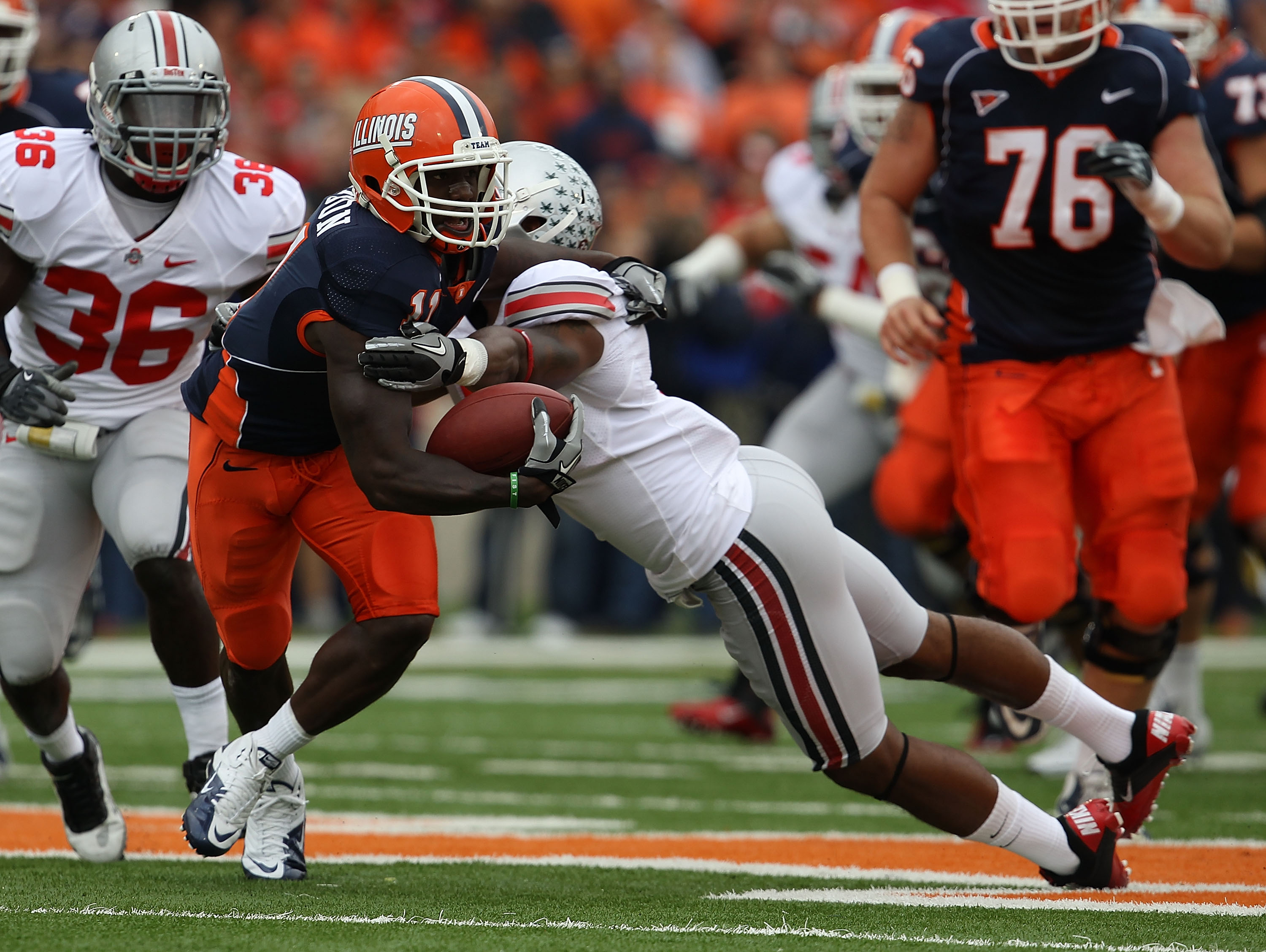 CHAMPAIGN, IL - OCTOBER 02: Jarred Fayson #11 of the Illinois Fighting Illini tries to escape Corey Brown #3 of the Ohio State Buckeyes at Memorial Stadium on October 2, 2010 in Champaign, Illinois. Ohio State defeated Illinois 24-13. (Photo by Jonathan D
