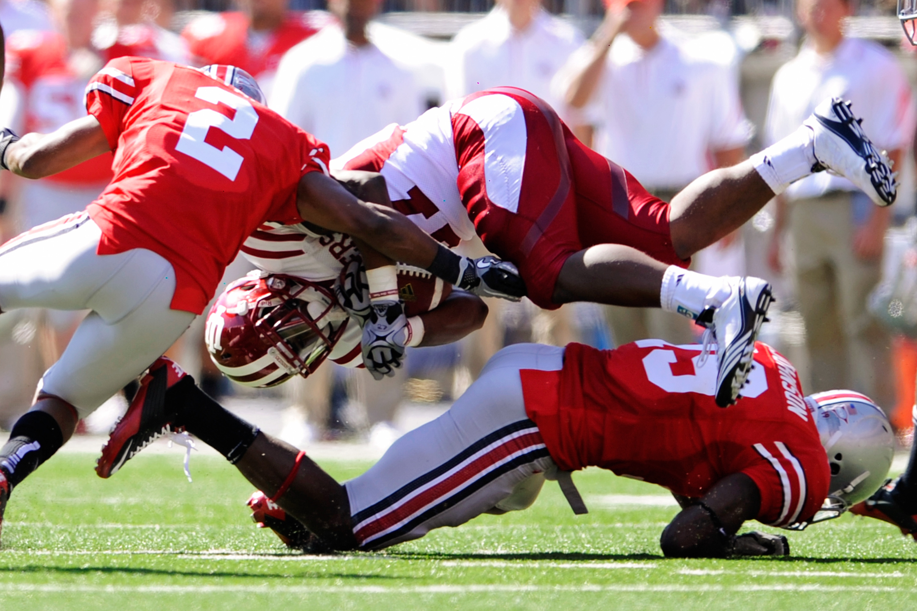 COLUMBUS, OH - OCTOBER 9:  Antonio Banks #27 of the Indiana Hoosiers is upended by Orhian Johnson #19 and Christian Bryant #2 of the Ohio State Buckeyes at Ohio Stadium on October 9, 2010 in Columbus, Ohio.  (Photo by Jamie Sabau/Getty Images)