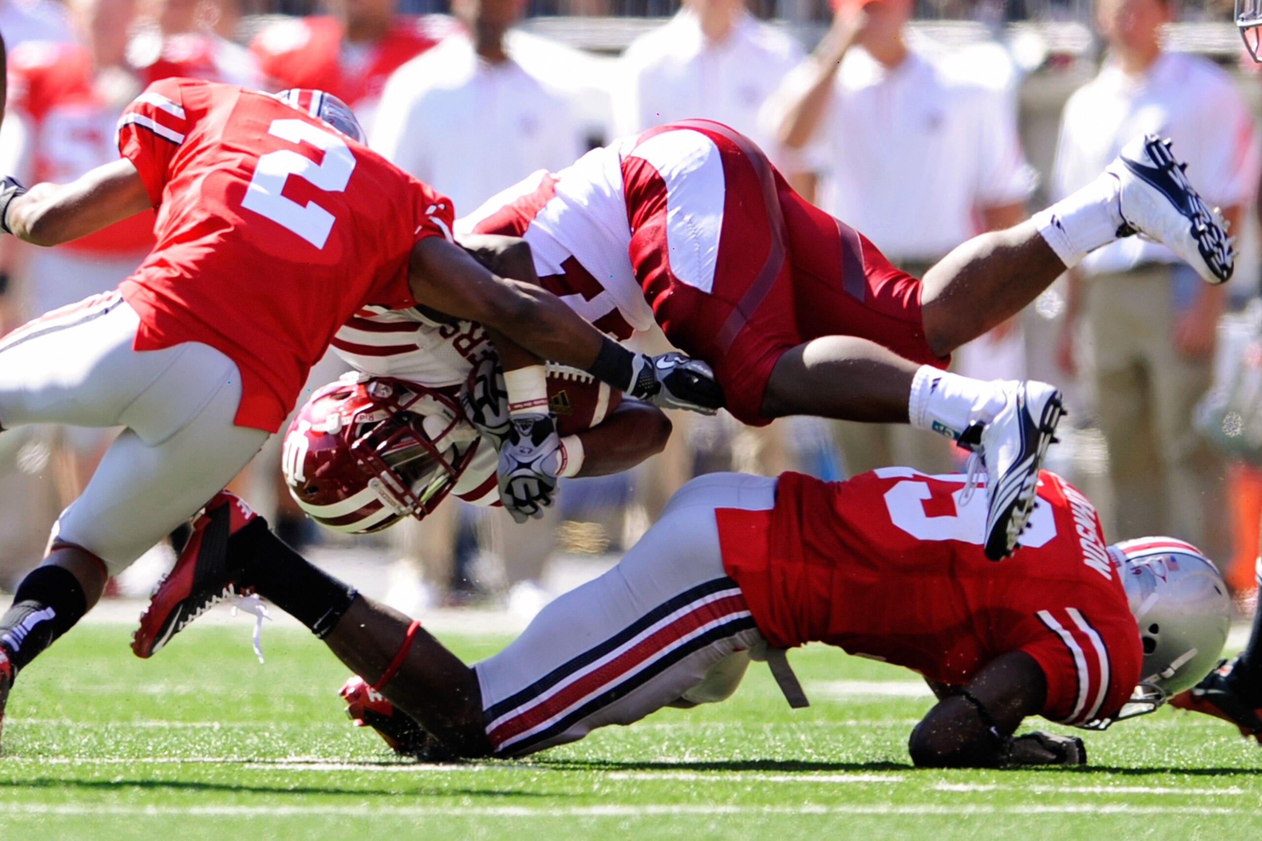 COLUMBUS, OH - OCTOBER 9:  Antonio Banks #27 of the Indiana Hoosiers is upended by Orhian Johnson #19 and Christian Bryant #2 of the Ohio State Buckeyes at Ohio Stadium on October 9, 2010 in Columbus, Ohio.  (Photo by Jamie Sabau/Getty Images)