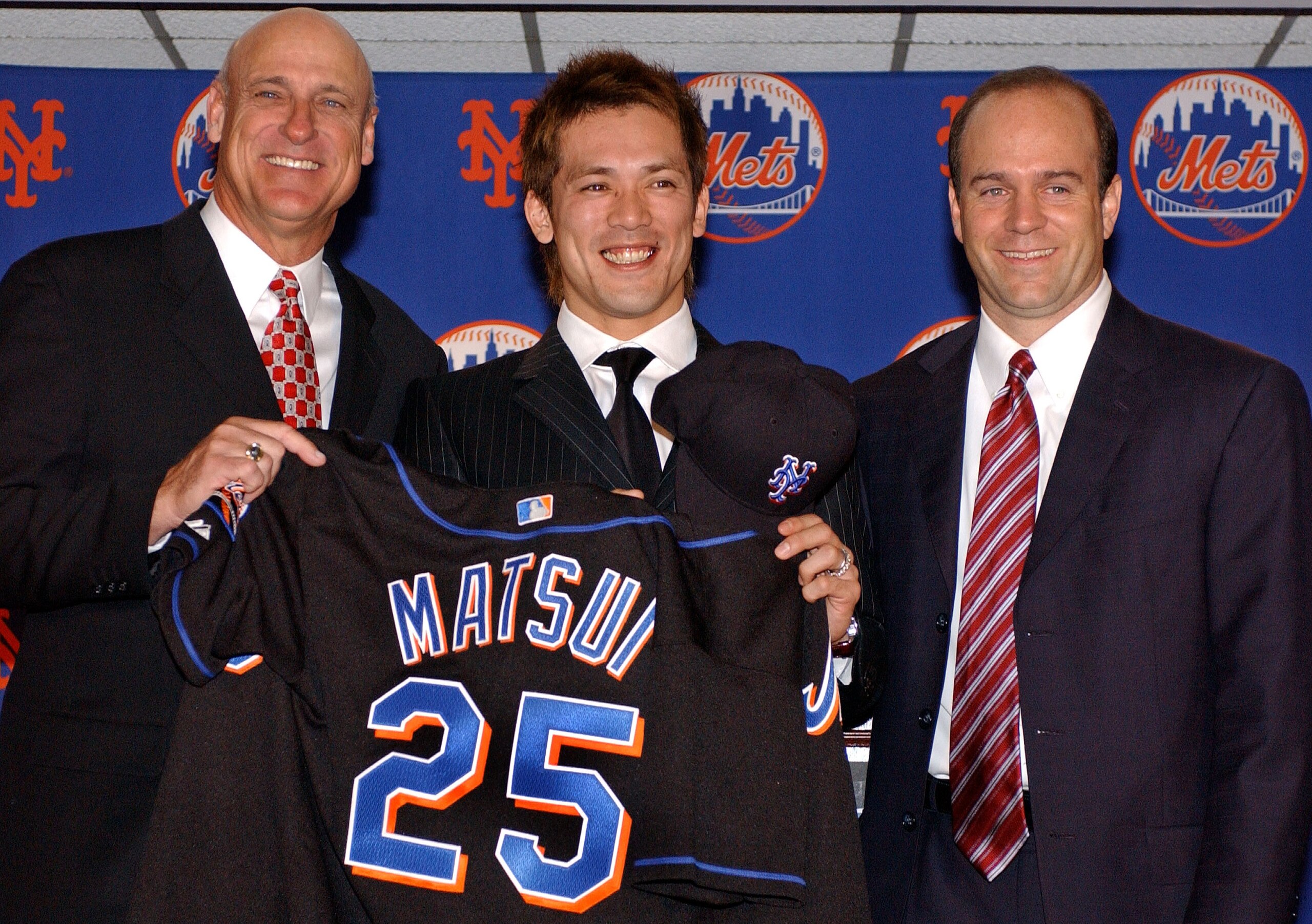 NEW YORK -DECEMBER 10:  New York Mets shortstop Kazuo Matsui (C) holds his new Mets jersey as he stands with Mets manager Art Howe (L) and General Manager Jim Duquette (R) during a press conference December 10, 2003 in New York City. Kazuo signed a $20.1