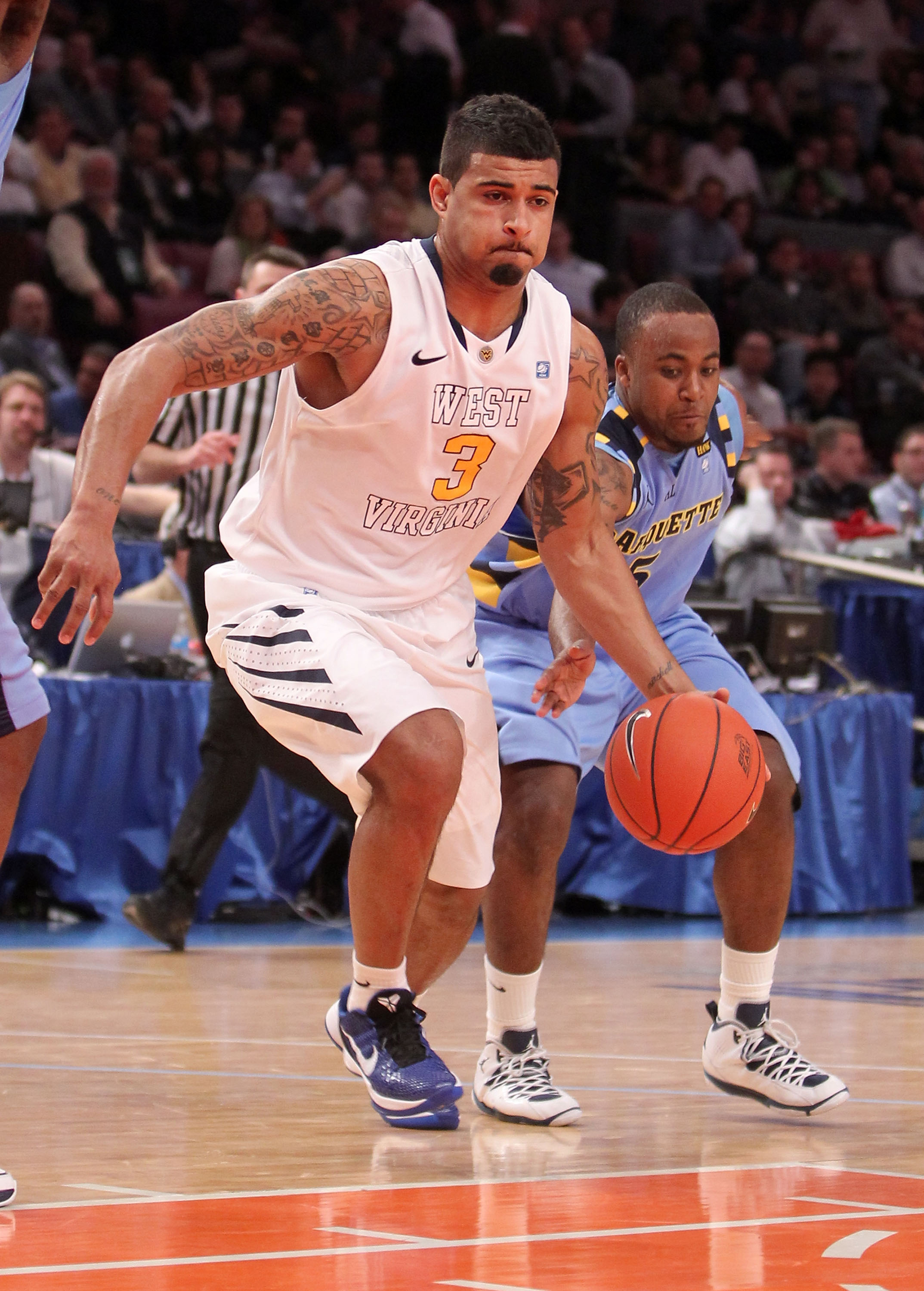 NEW YORK, NY - MARCH 09: Casey Mitchell #3 of the West Virginia Mountaineers tries to dribble passed Junior Cadougan #5 of the Marquette Golden Eagles during the second round of the 2011 Big East Men's Basketball Tournament presented by American Eagle Out