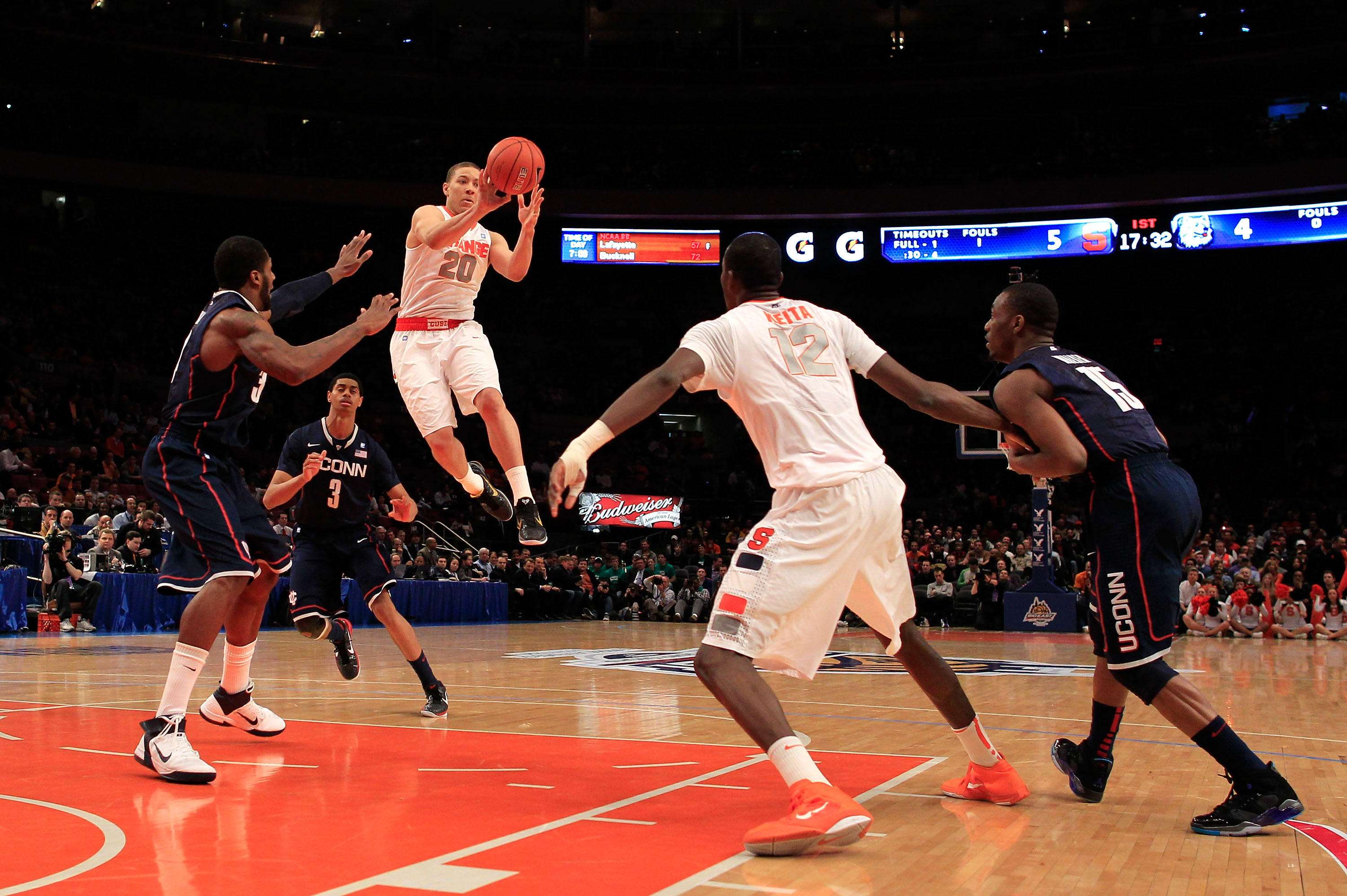 NEW YORK, NY - MARCH 11: Brandon Triche #20 of the Syracuse Orange looks to pass to Baye Moussa Keita #12 as Alex Oriakhi #34 and Kemba Walker #15 of the Connecticut Huskies defend during the semifinals of the 2011 Big East Men's Basketball Tournament pre