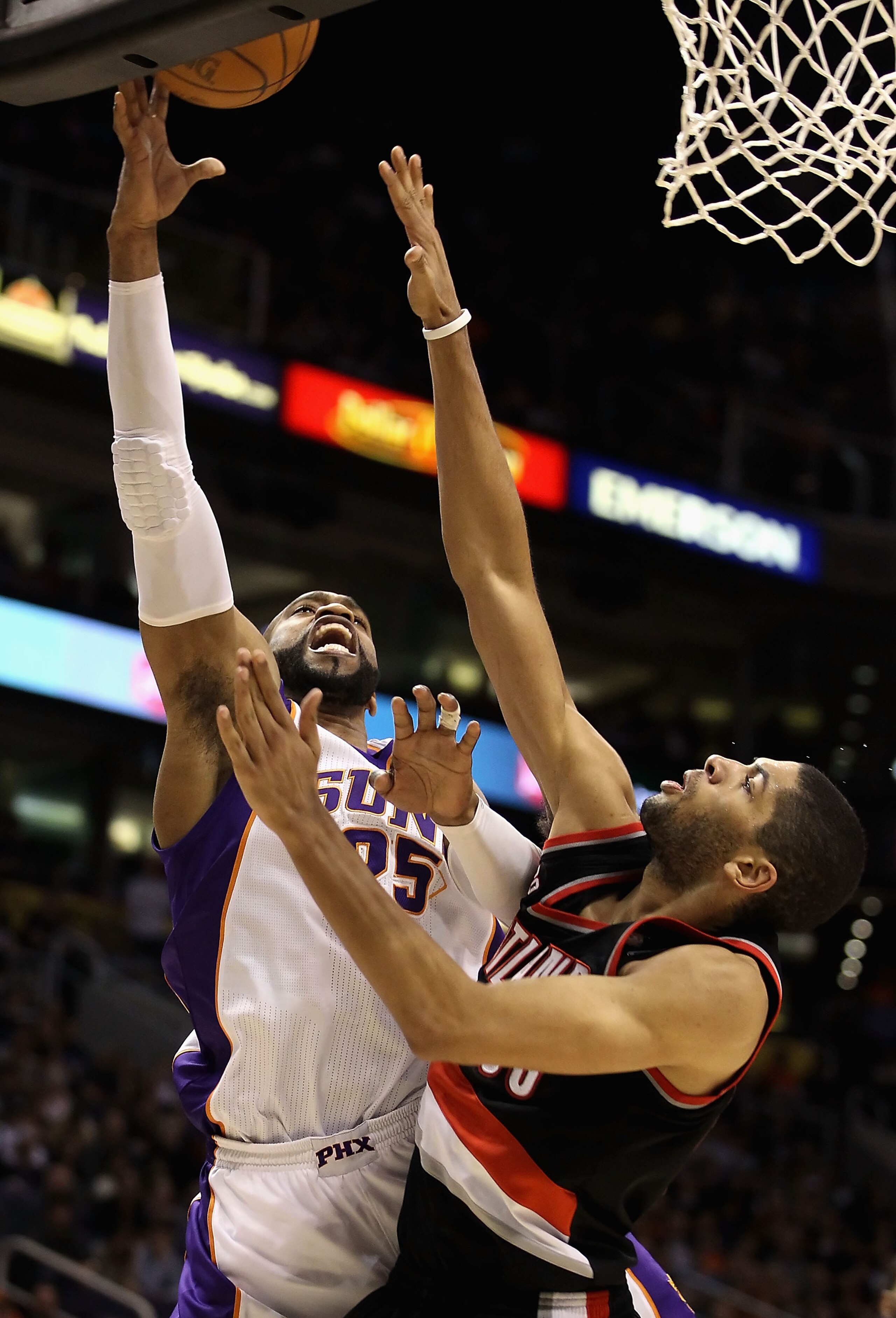 PHOENIX, AZ - JANUARY 14:  Vince Carter #25 of the Phoenix Suns lays up a shot over Nicolas Batum #88 of the Portland Trail Blazers during the NBA game at US Airways Center on January 14, 2011 in Phoenix, Arizona. The Suns defeated the Trail Blazers 115-1