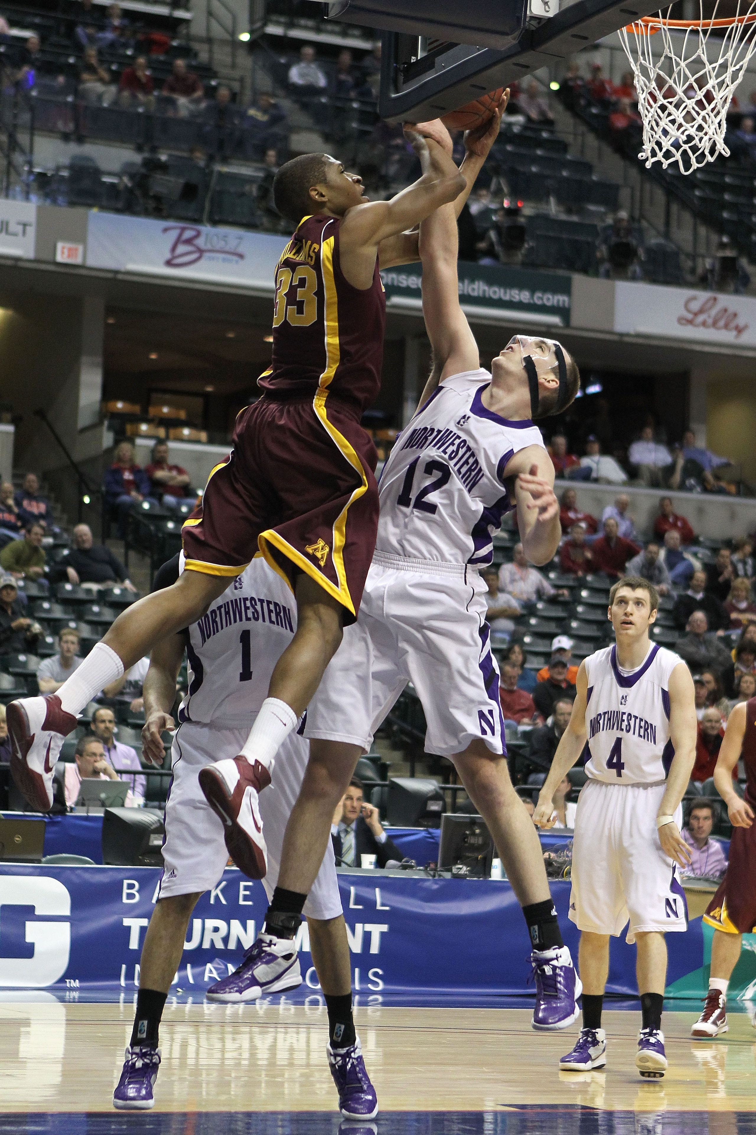 INDIANAPOLIS, IN - MARCH 10:  Rodney Williams #33 of the Minnesota Golden Gophers goes up for a shot attempt against Luka Mirkovic #12 of the Northwestern Wildcats during the first round of the 2011 Big Ten Men's Basketball Tournament at Conseco Fieldhous