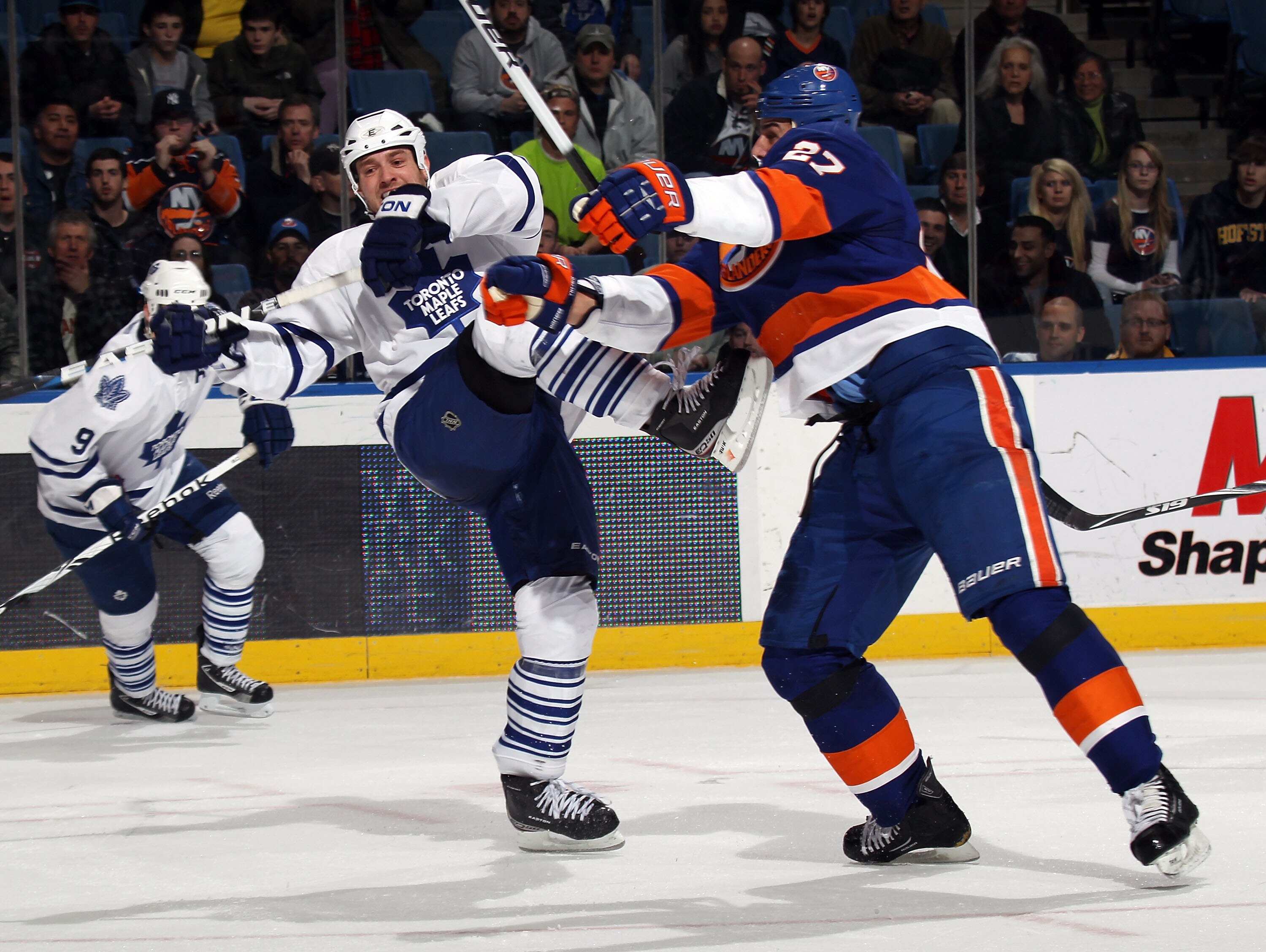 UNIONDALE, NY - MARCH 08: Milan Jurcina #27 of the New York Islanders hits Tim Brent #37 of the Toronto Maple Leafs in the third period at the Nassau Coliseum on March 8, 2011 in Uniondale, New York. The Islanders defeated the Maple Leafs 4-3 in overtime.