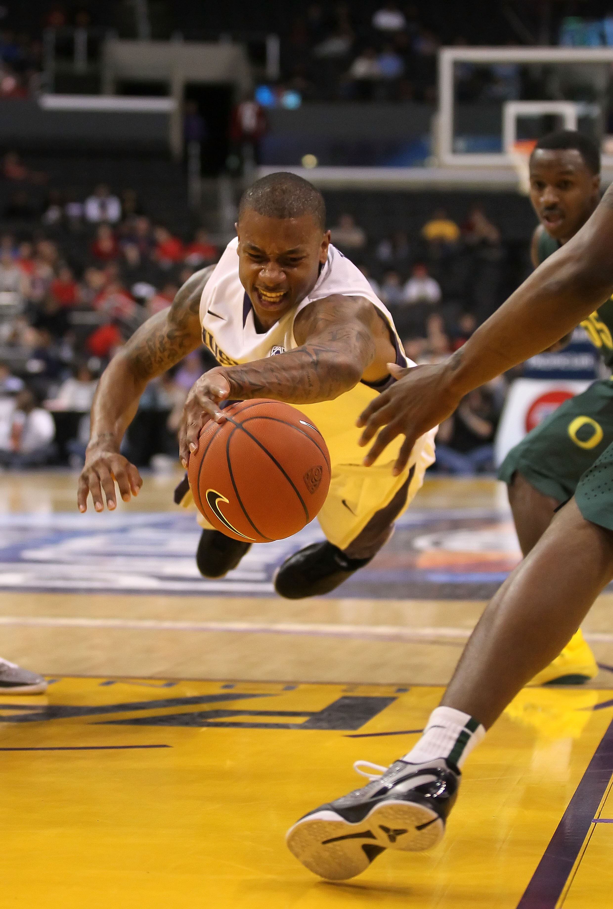 LOS ANGELES, CA - MARCH 11:  Isaiah Thomas #2 of the Washington Huskies falls through the lane with the ball in the first half while taking on the Oregon Ducks in the semifinals of the 2011 Pacific Life Pac-10 Men's Basketball Tournament at Staples Center