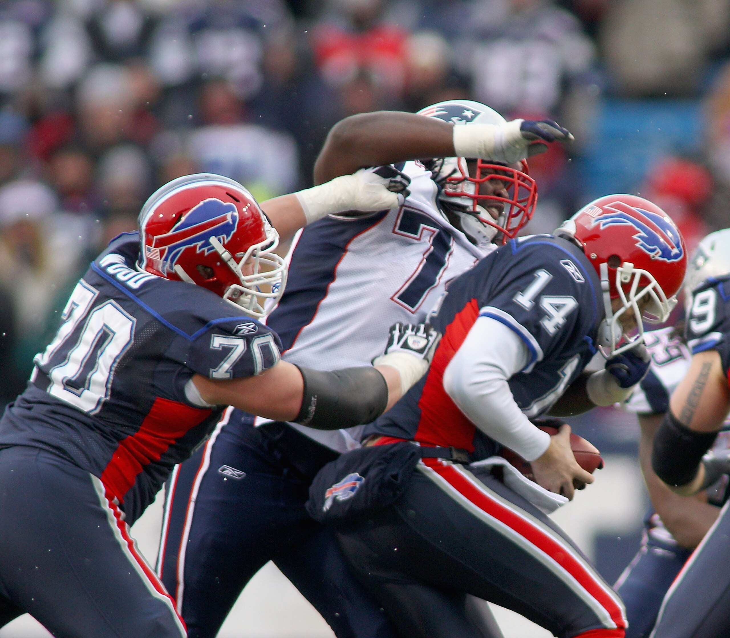 ORCHARD PARK, NY - DECEMBER 26:  Kyle Love #74  of the New England Patriots sacks Ryan Fitzpatrick #14 of the Buffalo Bills as Eric Wood #70 of the Bills tries to block at Ralph Wilson Stadium on December 26, 2010 in Orchard Park, New York. New England wo