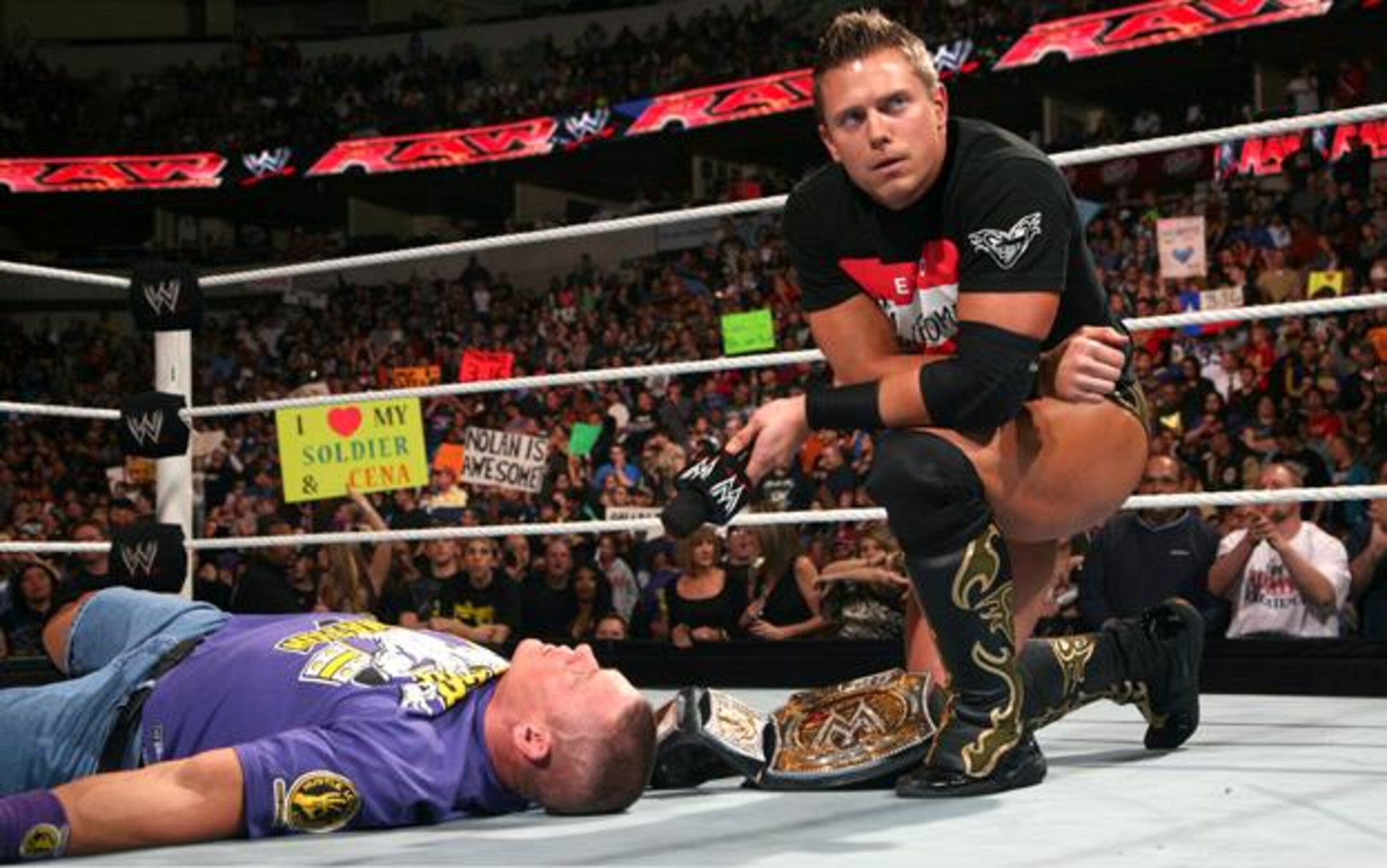 The Miz kneeling over Cena after beating him down