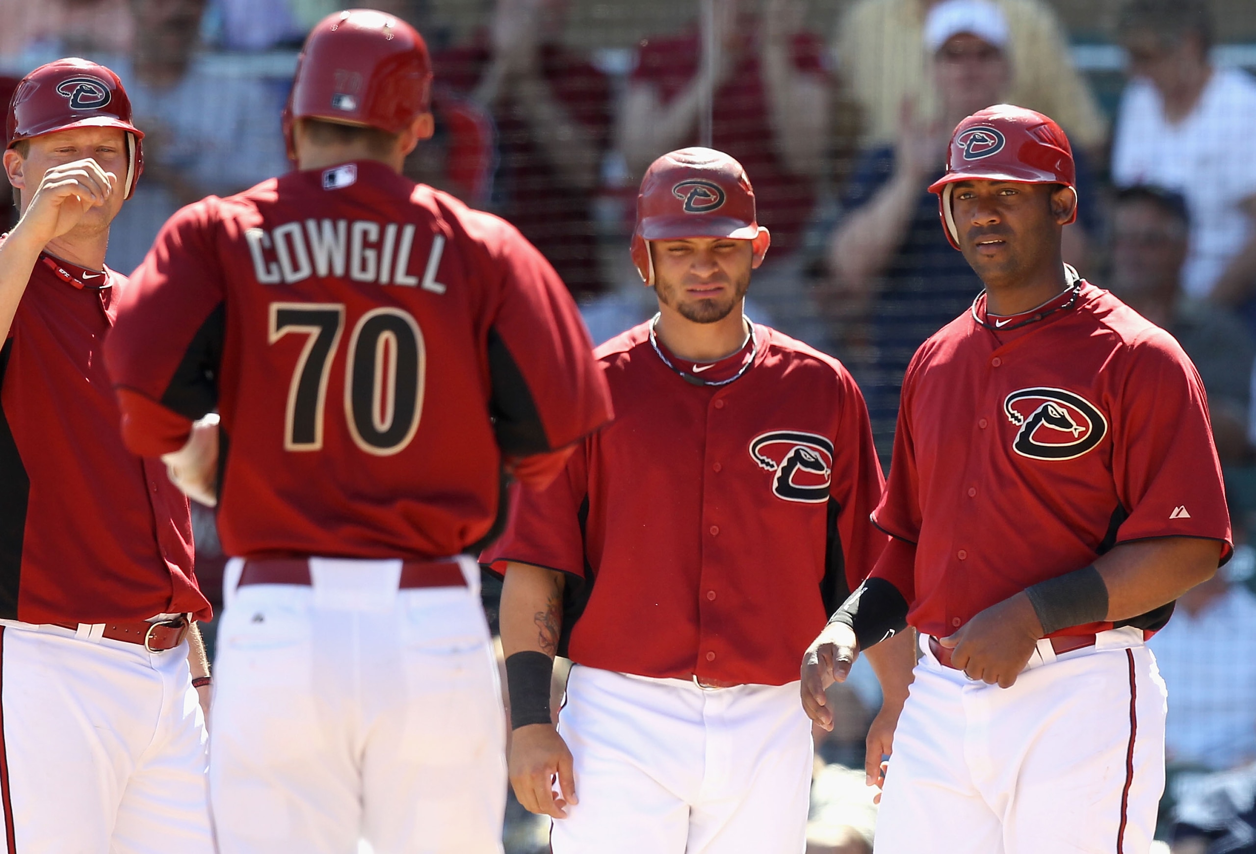 SCOTTSDALE, AZ - MARCH 09:  Collin Cowgill #70 of the Arizona Diamondbacks is met by teammates Geoff Blum #27, Gerardo Parra #8 and Juan Miranda #46 at home plate after Cowgill hit a grand slam against the Milwaukee Brewers during the first inning of the