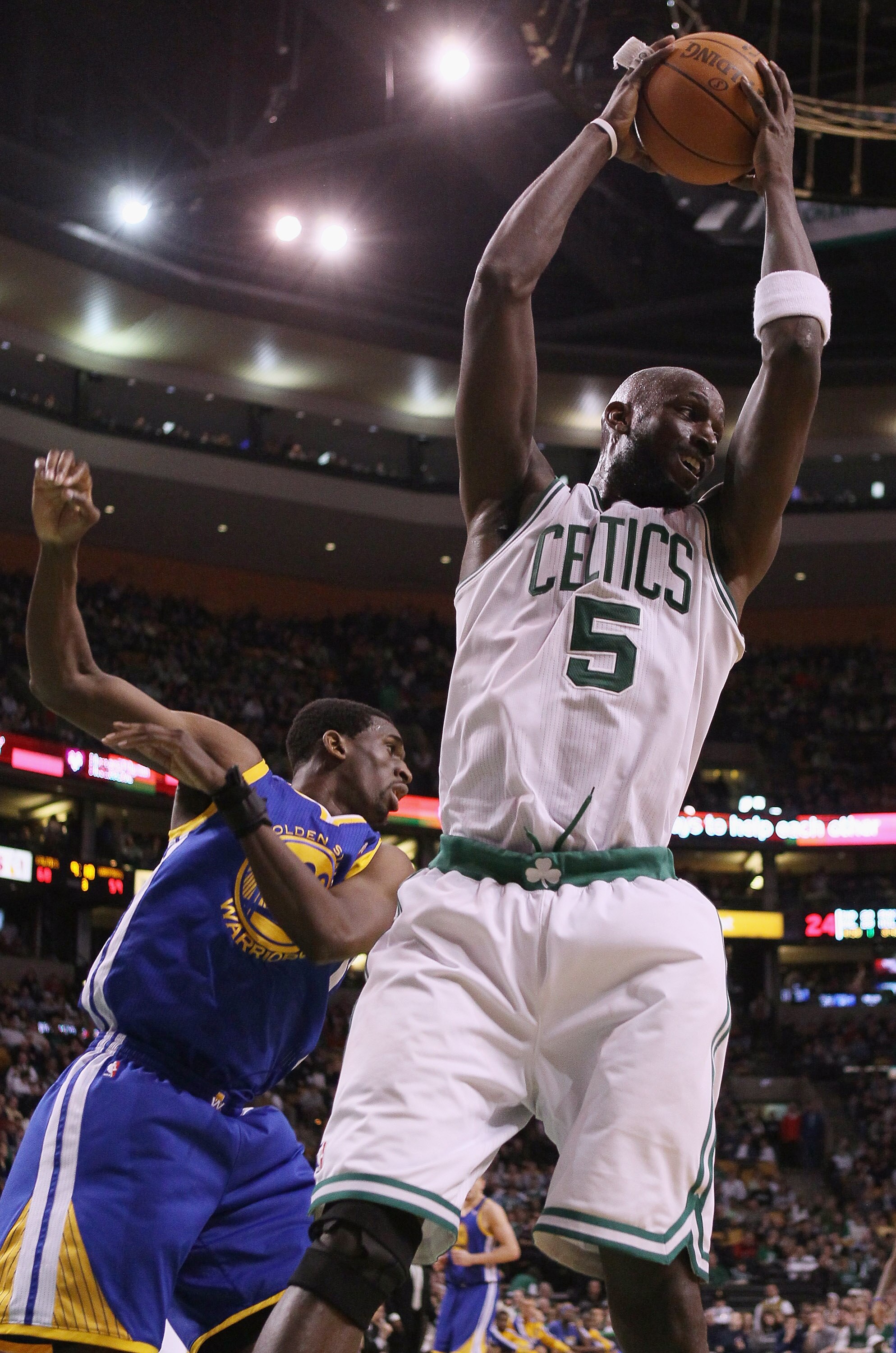 BOSTON, MA - MARCH 04:  Kevin Garnett #5 of the Boston Celtics grabs the rebound from Ekpe Udoh #20 of the Golden State Warriors on March 4, 2011 at the TD Garden in Boston, Massachusetts.  The Celtics defeated the Warriors 107-103. NOTE TO USER: User exp