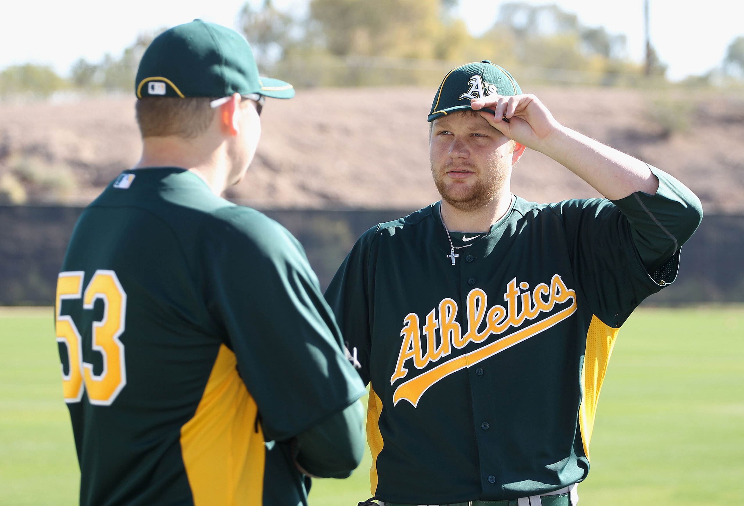 PHOENIX, AZ - FEBRUARY 16:  (L-R) Pitchers Trevor Cahill #53 and Brett Anderson #49 of the Oakland Athletics warm up during a MLB spring training practice at Phoenix Municipal Stadium on February 16, 2011 in Phoenix, Arizona.  (Photo by Christian Petersen