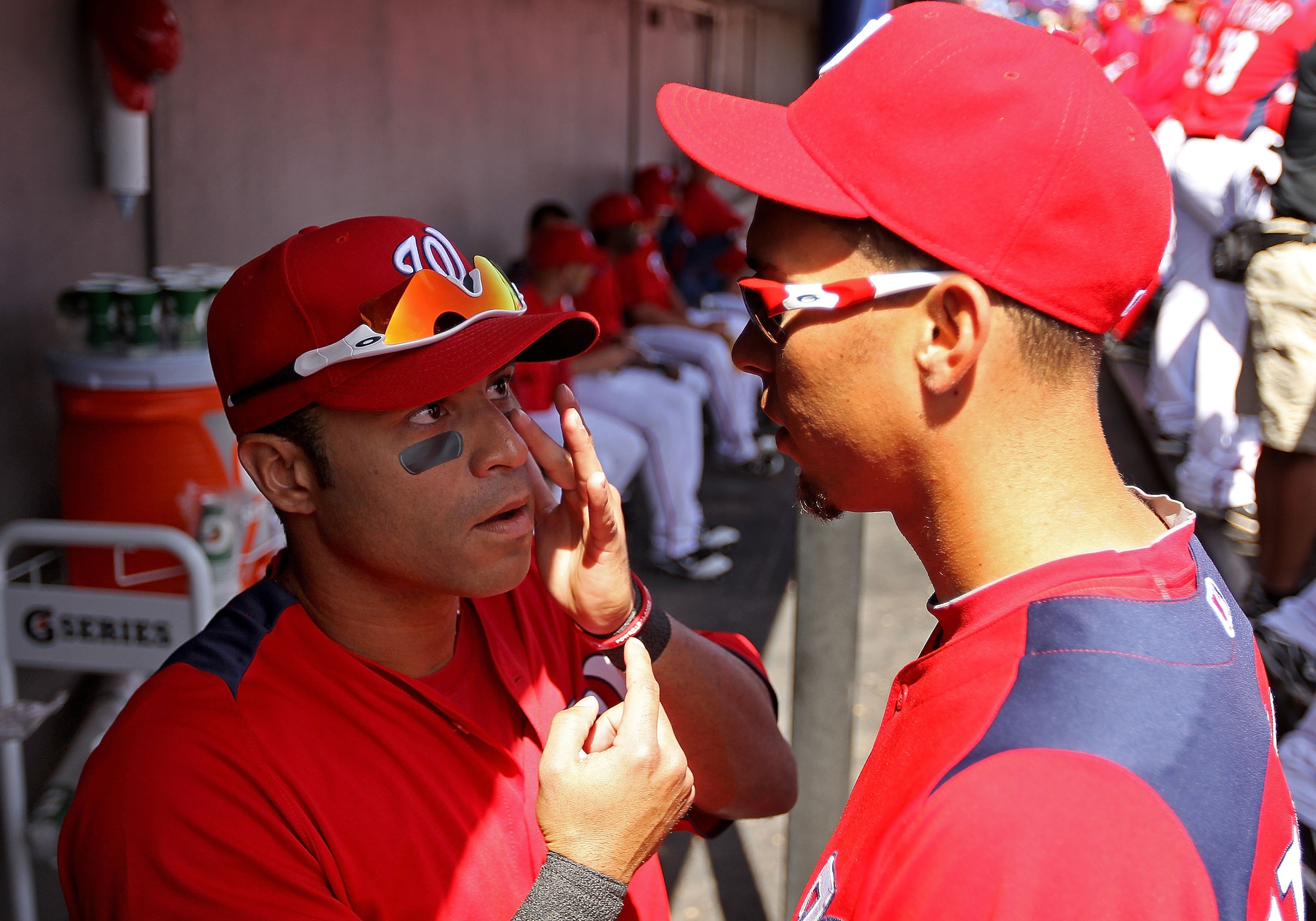 VIERA, FL - MARCH 02:  Jerry Hairston Jr. #15 of the Washington Nationals fixes his eye black in Luis Atilano's #56 glasses during a Spring Training game against the Florida Marlins at Space Coast Stadium on March 2, 2011 in Viera, Florida.  (Photo by Mik