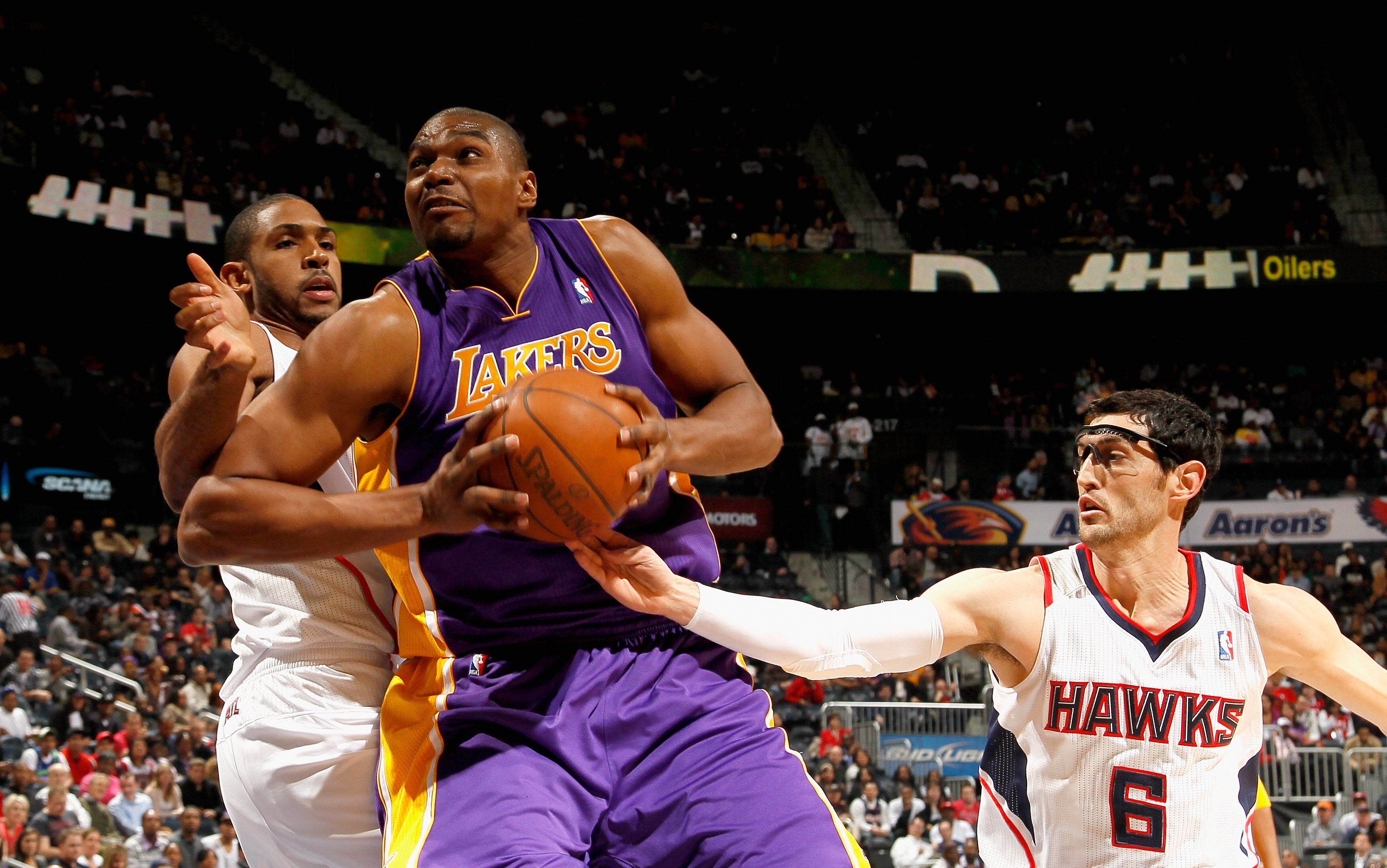 ATLANTA, GA - MARCH 08:  Andrew Bynum #17 of the Los Angeles Lakers drives between Al Horford #15 and Kirk Hinrich #6 of the Atlanta Hawks at Philips Arena on March 8, 2011 in Atlanta, Georgia.  NOTE TO USER: User expressly acknowledges and agrees that, b