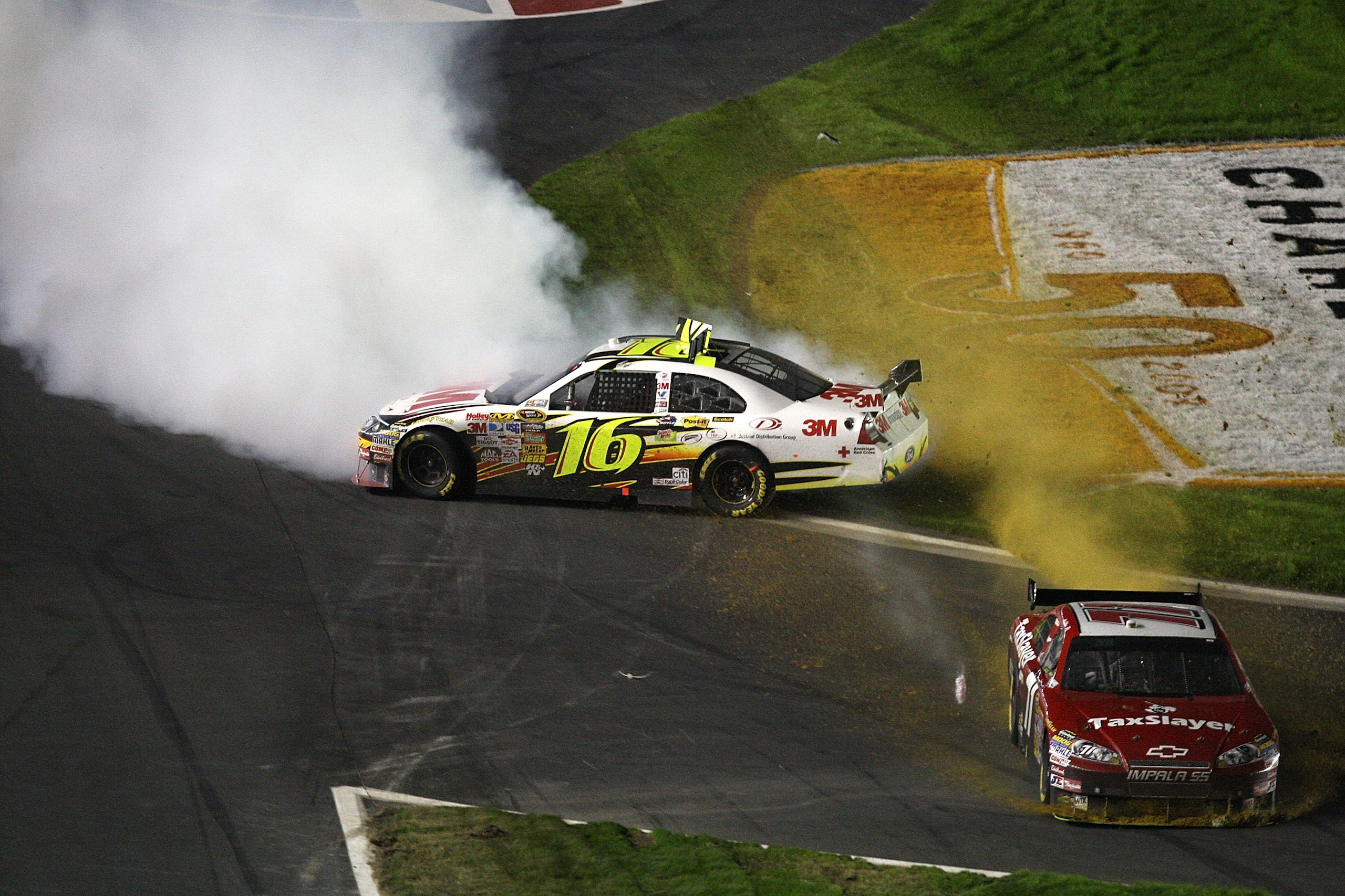 CONCORD, NC - OCTOBER 17:  Greg Biffle, driver of the #16 3M Ford, and Mike Bliss, driver of the #71 Taxslayer.com Chevrolet, slide through the infield after crashing during the NASCAR Sprint Cup Series NASCAR Banking 500 at Lowe's Motor Speedway on Octob