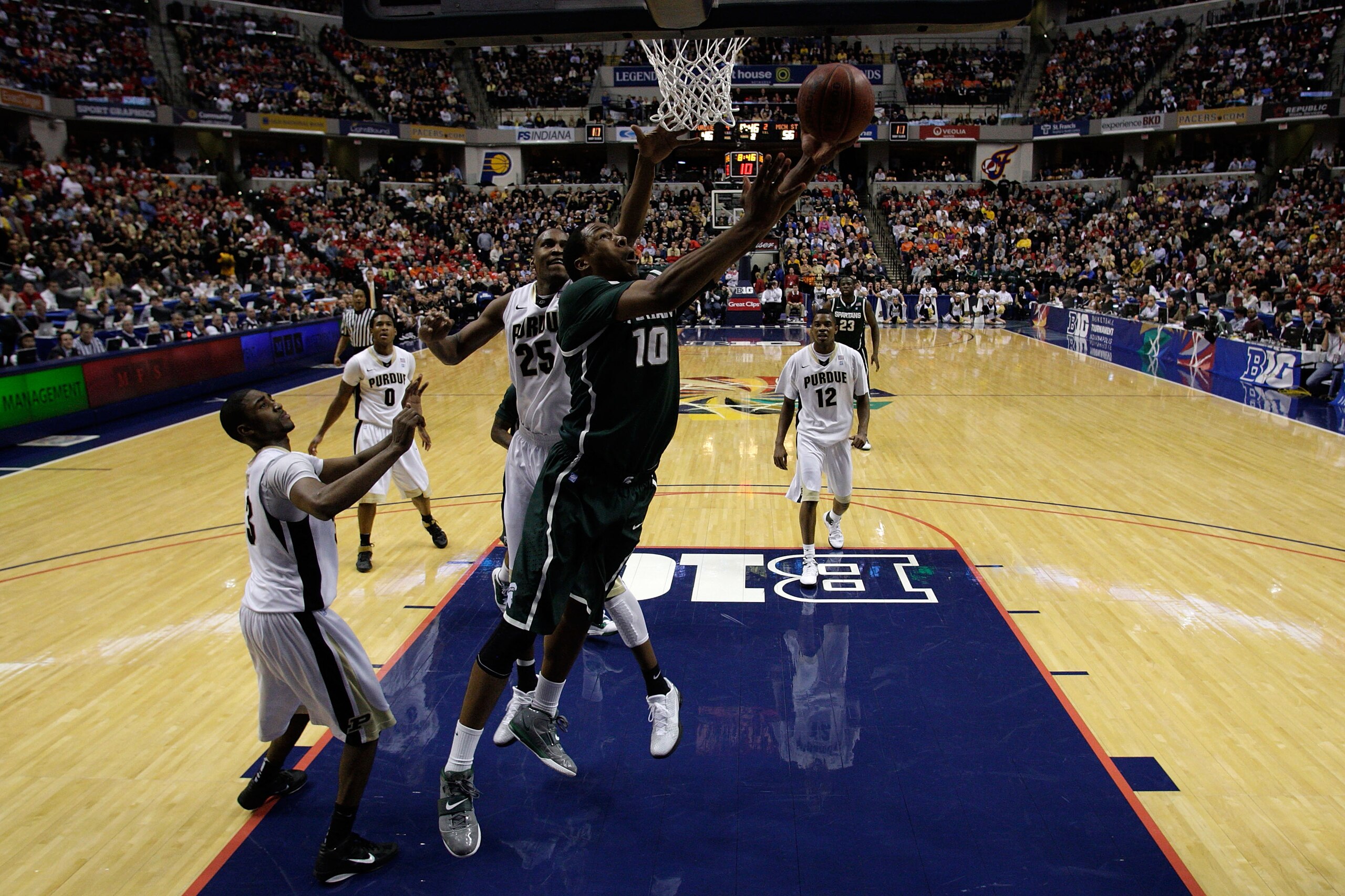INDIANAPOLIS, IN - MARCH 11:  Delvon Roe #10 of the Michigan State Spartans drives for a shot attempt against JaJuan Johnson #25 of the Purdue Boilermakers during the quarterfinals of the 2011 Big Ten Men's Basketball Tournament at Conseco Fieldhouse on M