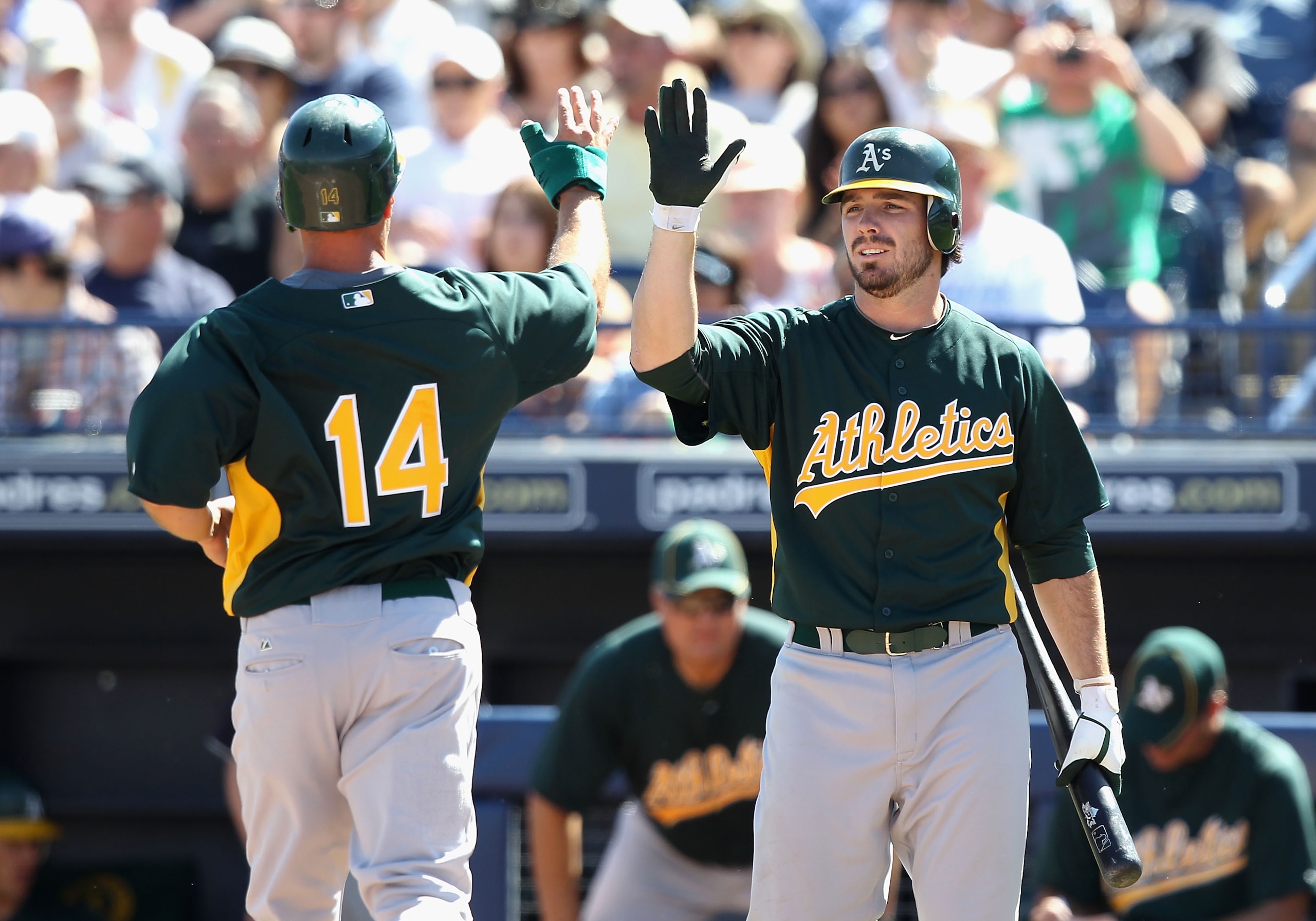 PEORIA, AZ - MARCH 12:  Mark Ellis #14 of the Oakland Athletics high fives teammate Andy LaRoche #21 after Ellis scored a run against the Seattle Mariners during the second inning of the spring training game at Peoria Stadium on March 12, 2011 in Peoria,