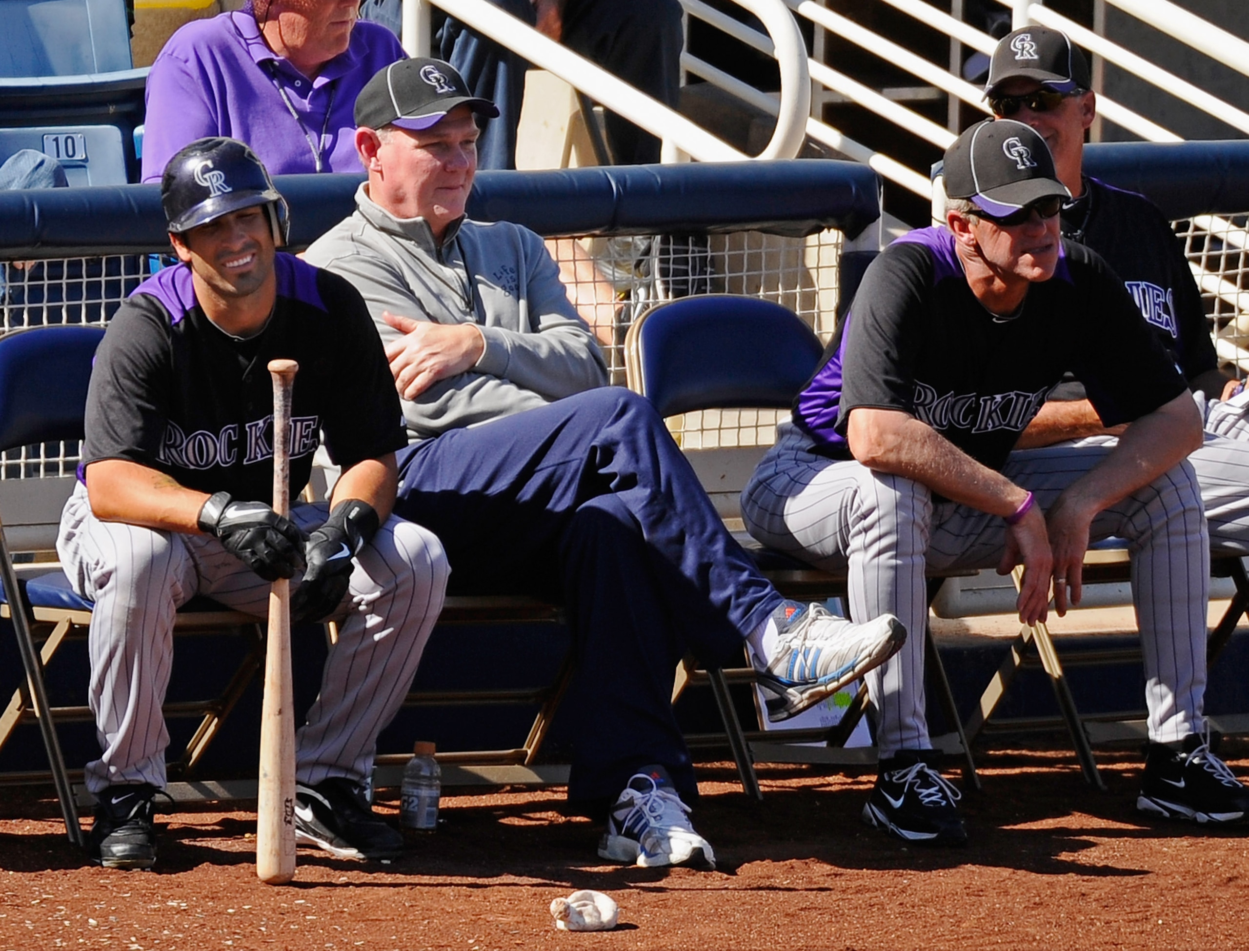 PHOENIX, AZ - MARCH 10:  George Karl (2nd-L) coach of the Denver Nuggets seated next to managerJim Tracy (R) and Ryan Spilborgs of the Colorado Rockies follows the acxtion against Milwaukee Brewers during the spring training baseball game at Maryvale Base