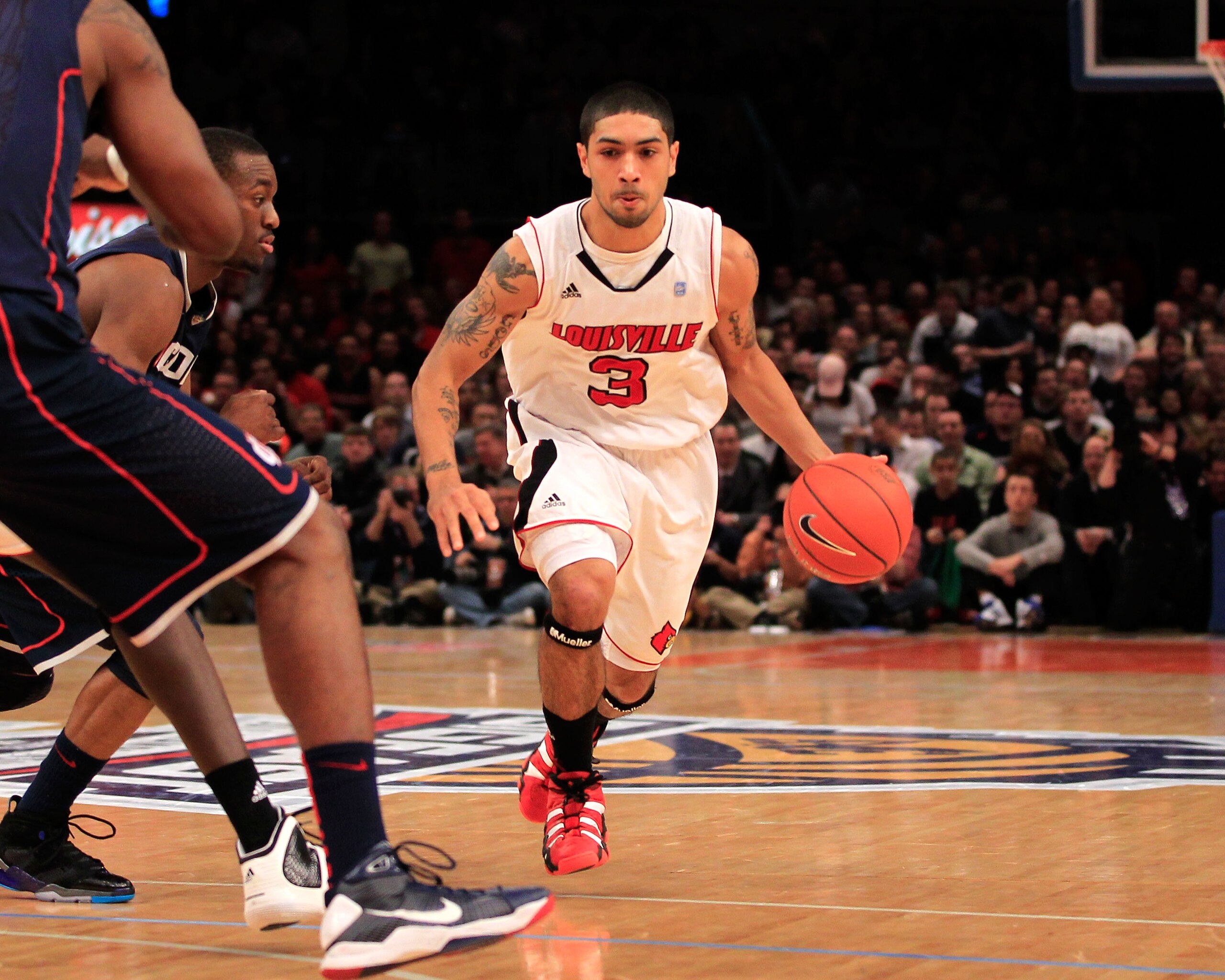NEW YORK, NY - MARCH 12:  Peyton Siva #3 of the Louisville Cardinals brings the ball up court against the Connecticut Huskies during the championship of the 2011 Big East Men's Basketball Tournament presented by American Eagle Outfitters at Madison Square