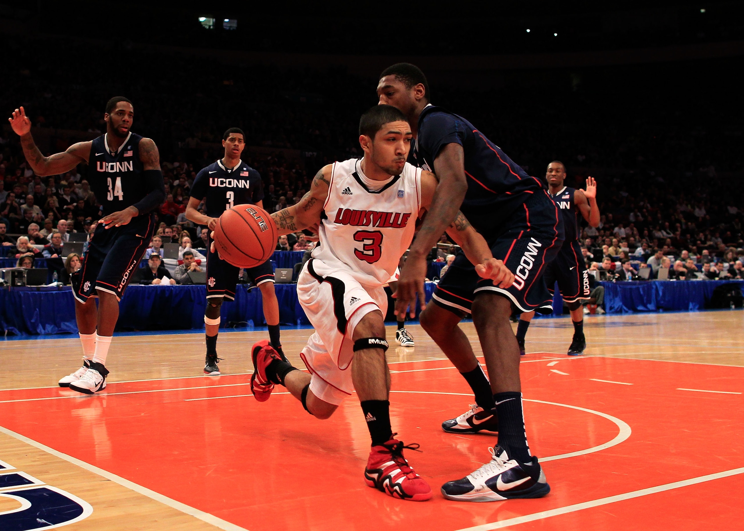 NEW YORK, NY - MARCH 12: Peyton Siva #3 of the Louisville Cardinals tries to dribble past Roscoe Smith #22 of the Connecticut Huskies during the championship of the 2011 Big East Men's Basketball Tournament presented by American Eagle Outfitters at Madiso