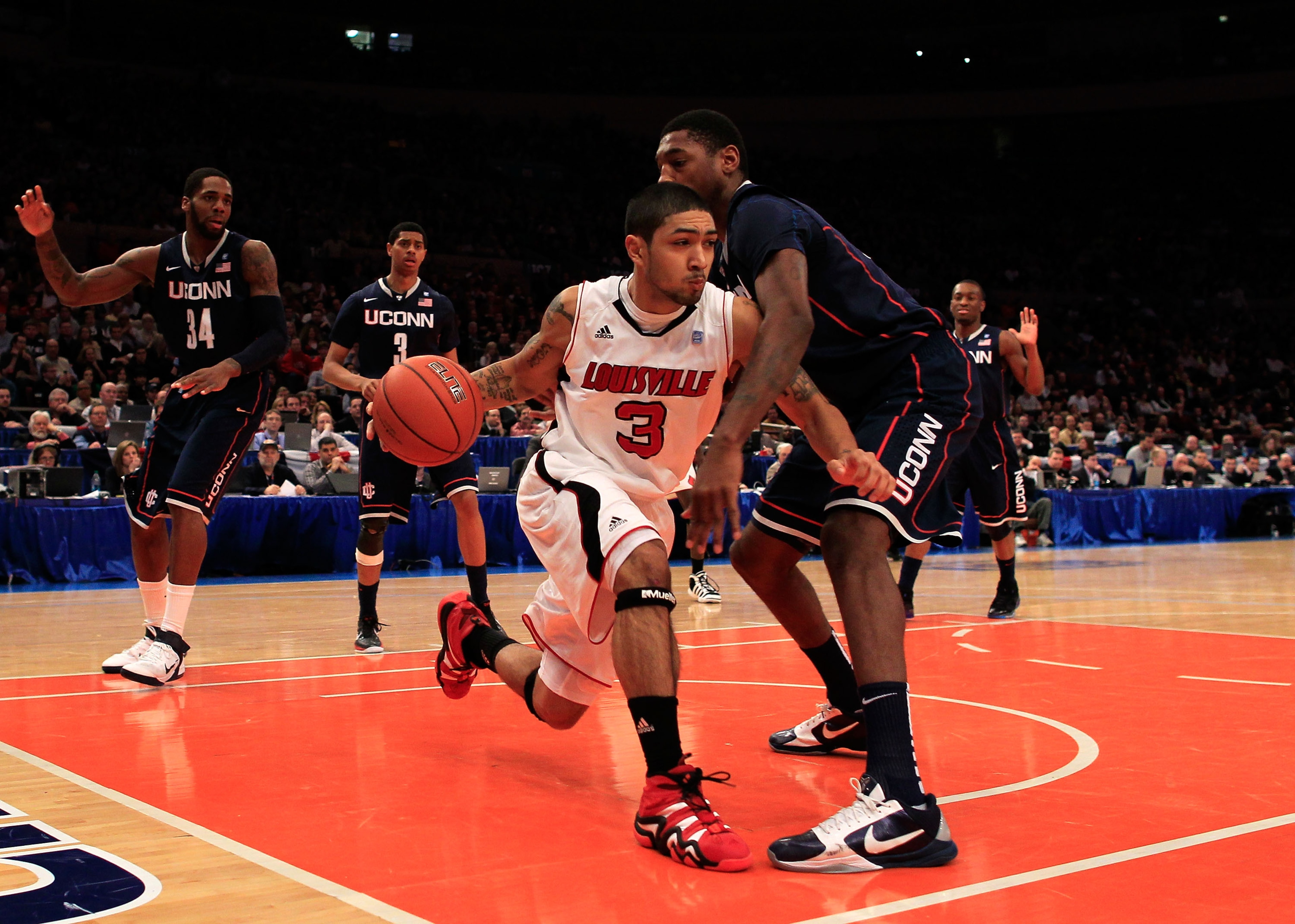 NEW YORK, NY - MARCH 12: Peyton Siva #3 of the Louisville Cardinals tries to dribble past Roscoe Smith #22 of the Connecticut Huskies during the championship of the 2011 Big East Men's Basketball Tournament presented by American Eagle Outfitters at Madiso