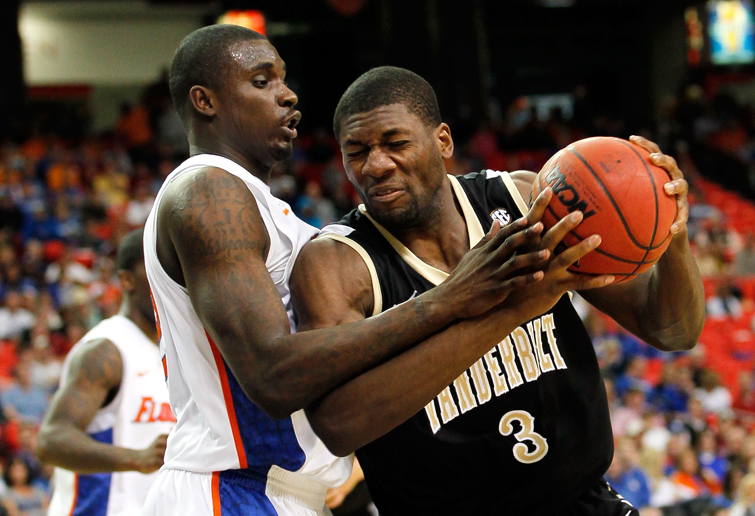 ATLANTA, GA - MARCH 12:  Festus Ezeli #3 of the Vanderbilt Commodores drives against Vernon Macklin #32 of the Florida Gators during the semifinals of the SEC Men's Basketball Tournament at Georgia Dome on March 12, 2011 in Atlanta, Georgia.  (Photo by Ke